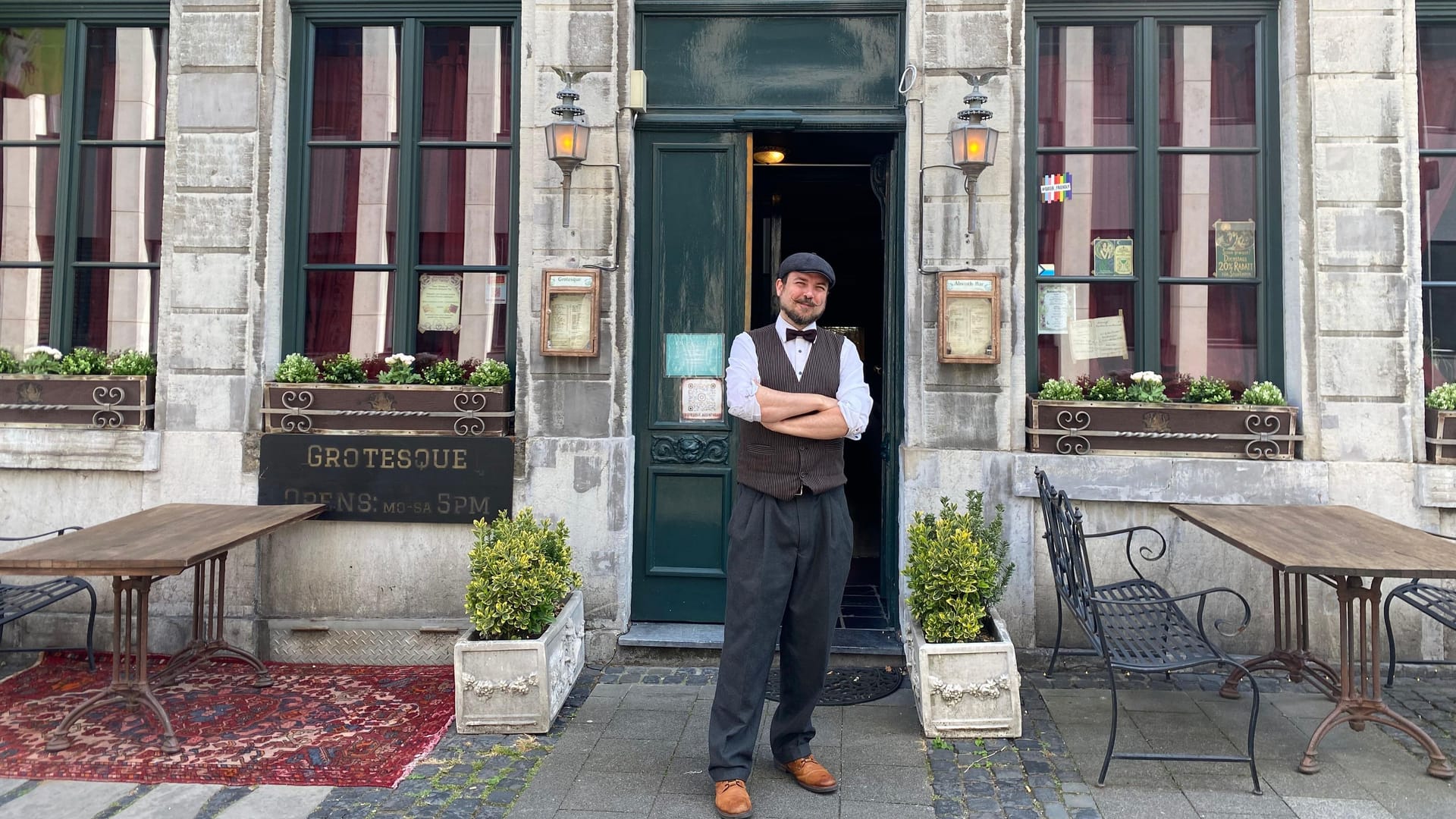 Stephan Kinting vor seiner Bar in Aachen: Schicke Weste, Fliege, Schiebermütze und ein gezwirbelter Bart gehören immer zu seinem Outfit.