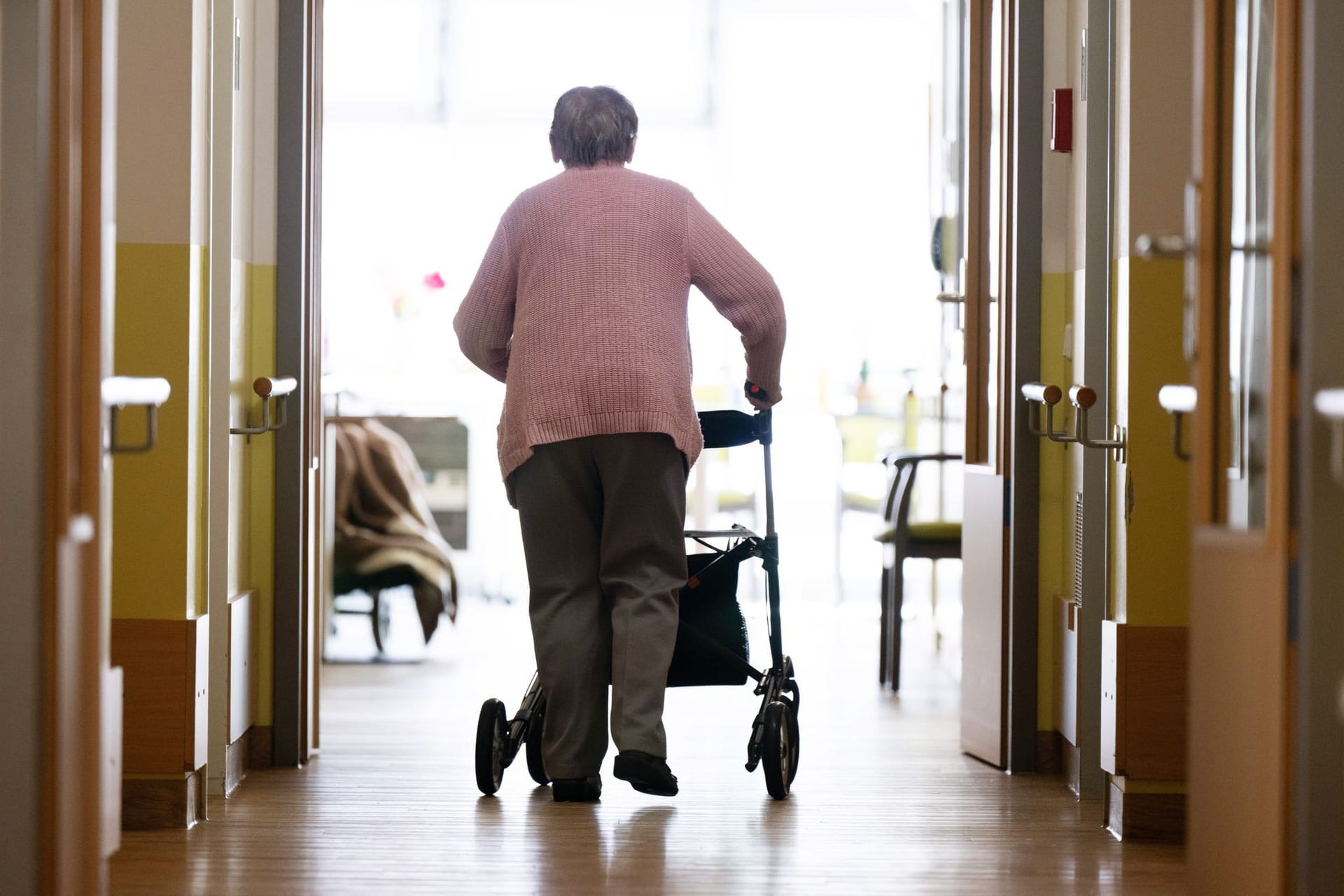 Frau geht mit Rollator in Altenheim (Archivfoto): In Hamburg steigen die Zuzahlungen für Pflegeheime deutlich.