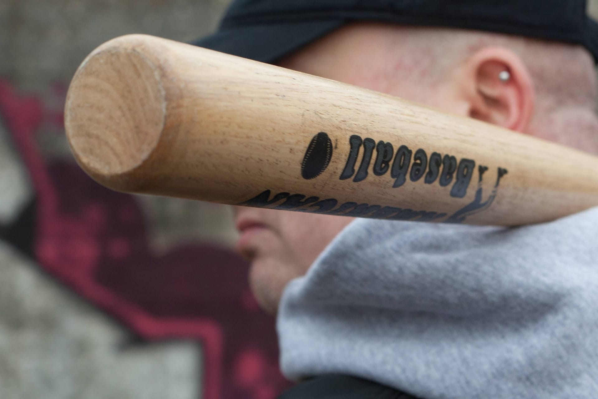 Ein Mann hält einen Baseballschläger (Symbolbild): In Syke hat eine Gruppe am Samstag ein Eiscafé überfallen.