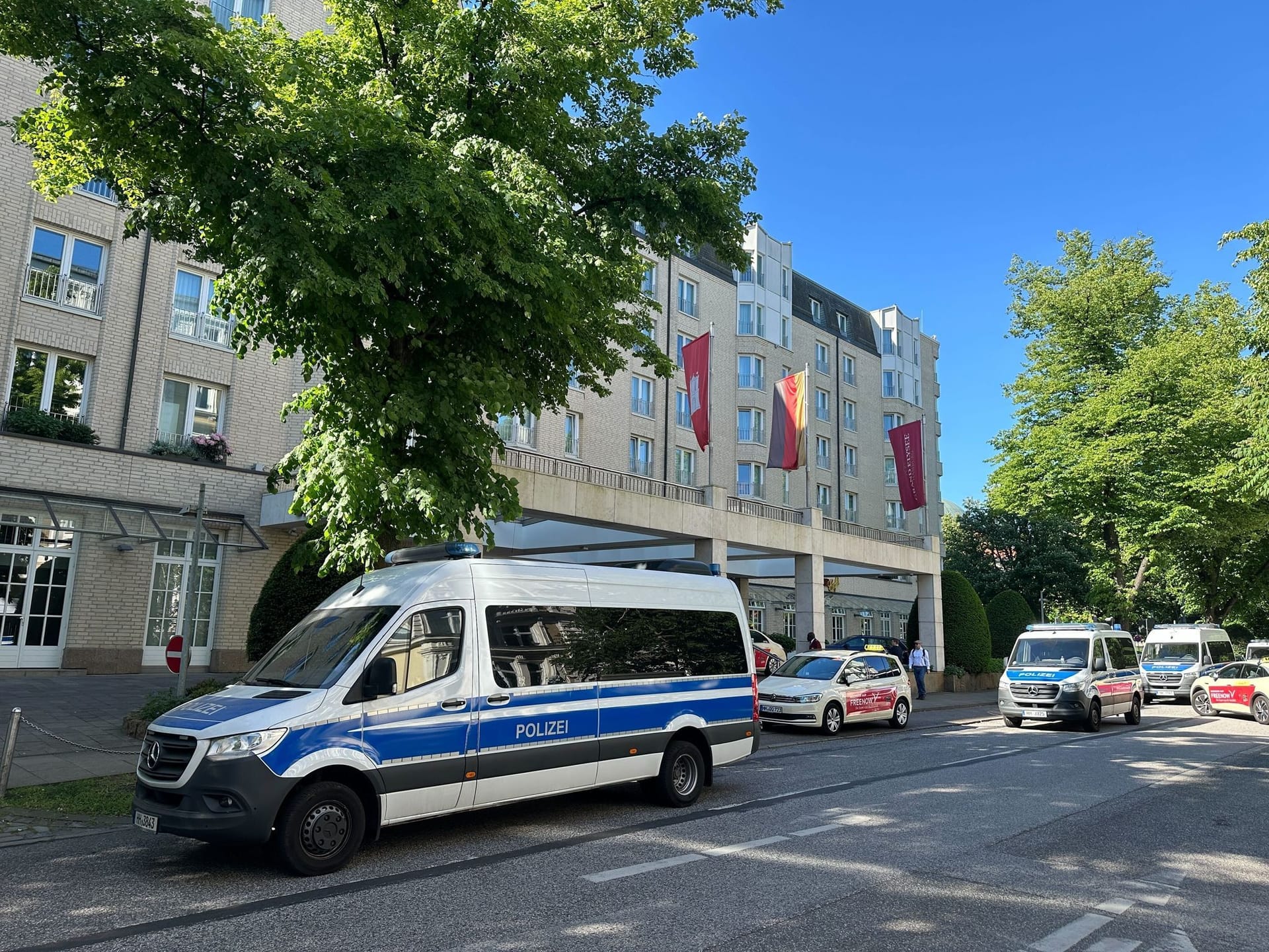 Polizeifahrzeugen stehen am Elysee-Hotel. Die Hamburger Polizei vollstreckte am 16. Mai 2024 einen Durchsuchungsbeschluss bei der Unternehmerfamilie Block und am Hotel.