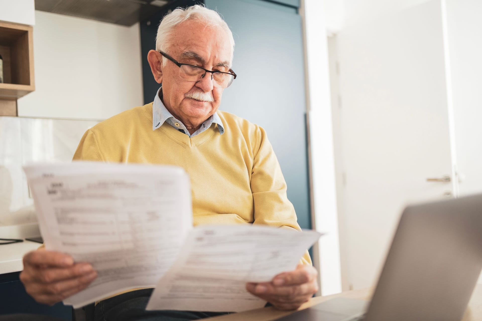Rentner liest einen Bescheid: Im Dezember 2025 erhalten manche Rentner einen neuen Rentenbescheid.