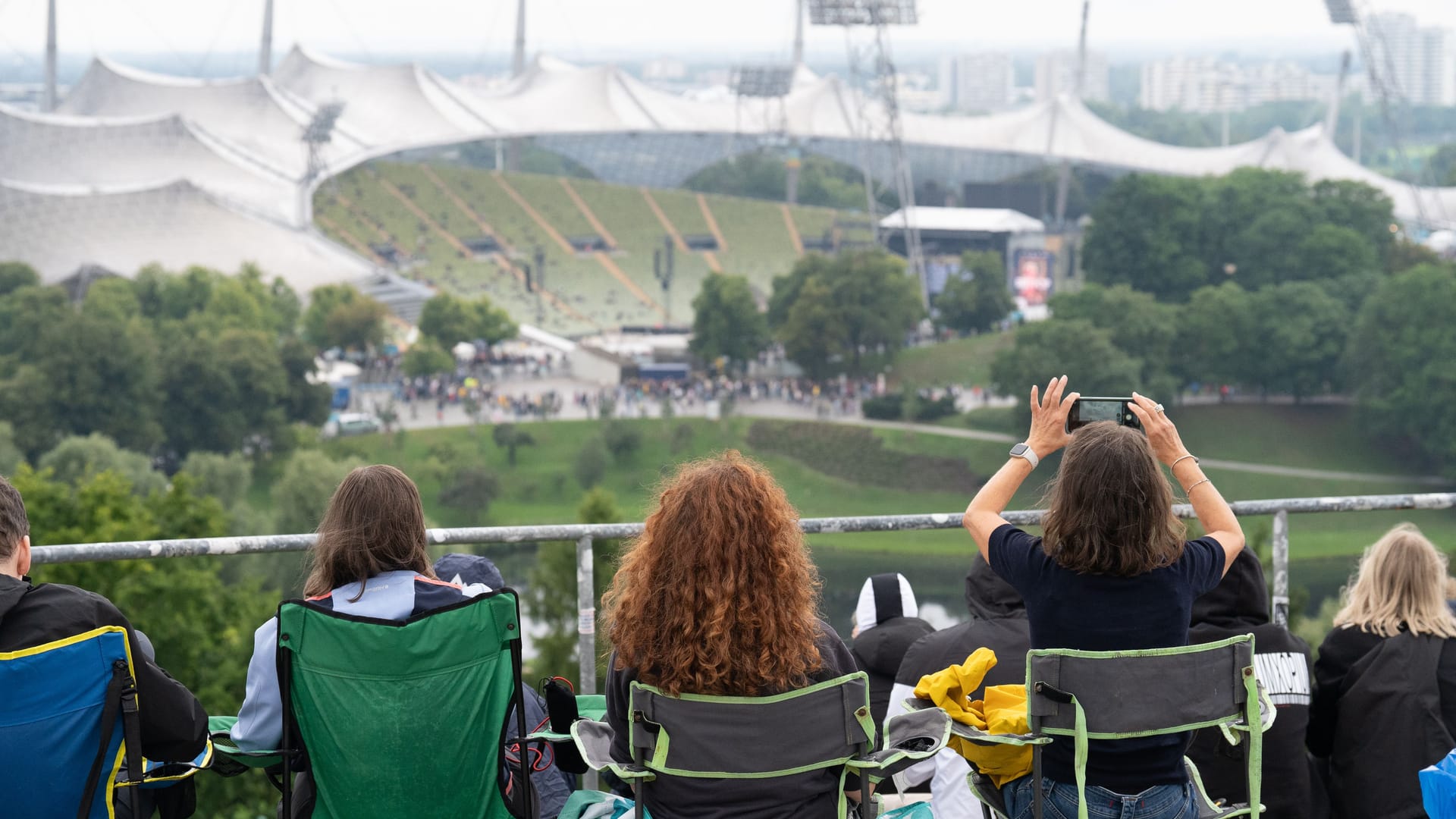 Fans sichern sich die besten Plätze mit Blick auf das Olympiastadion: In Campingstühlen verfolgen sie das Geschehen.
