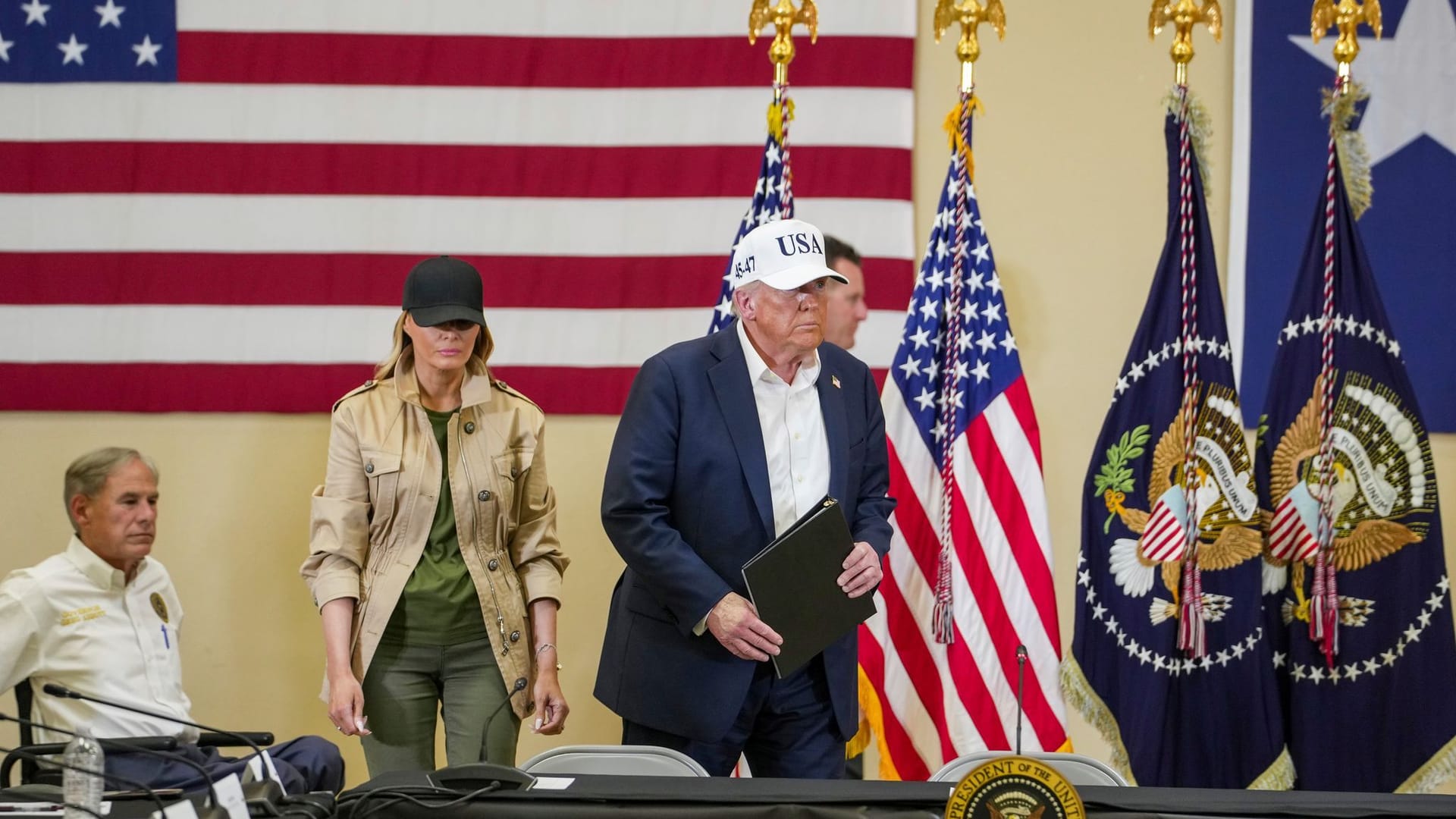 Donald Trump (Mitte, mit Kappe) und seine Frau Melania (links) auf dem Weg zu einer Pressekonferenz in Texas.