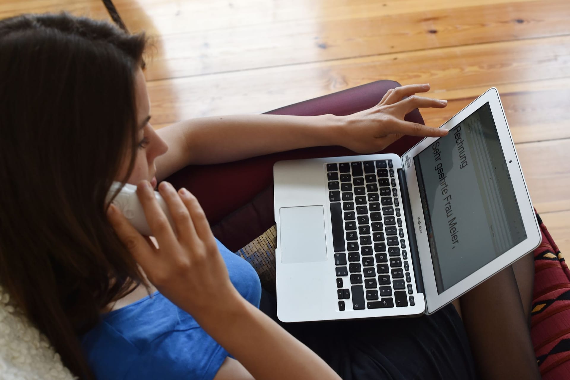 Frau mit Laptop telefoniert