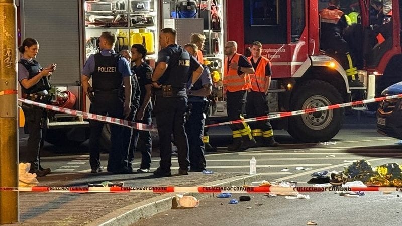Einsatzkräfte der Polizei und Feuerwehr stehen am Unfallort: Zwei junge Männer kamen ums Leben.