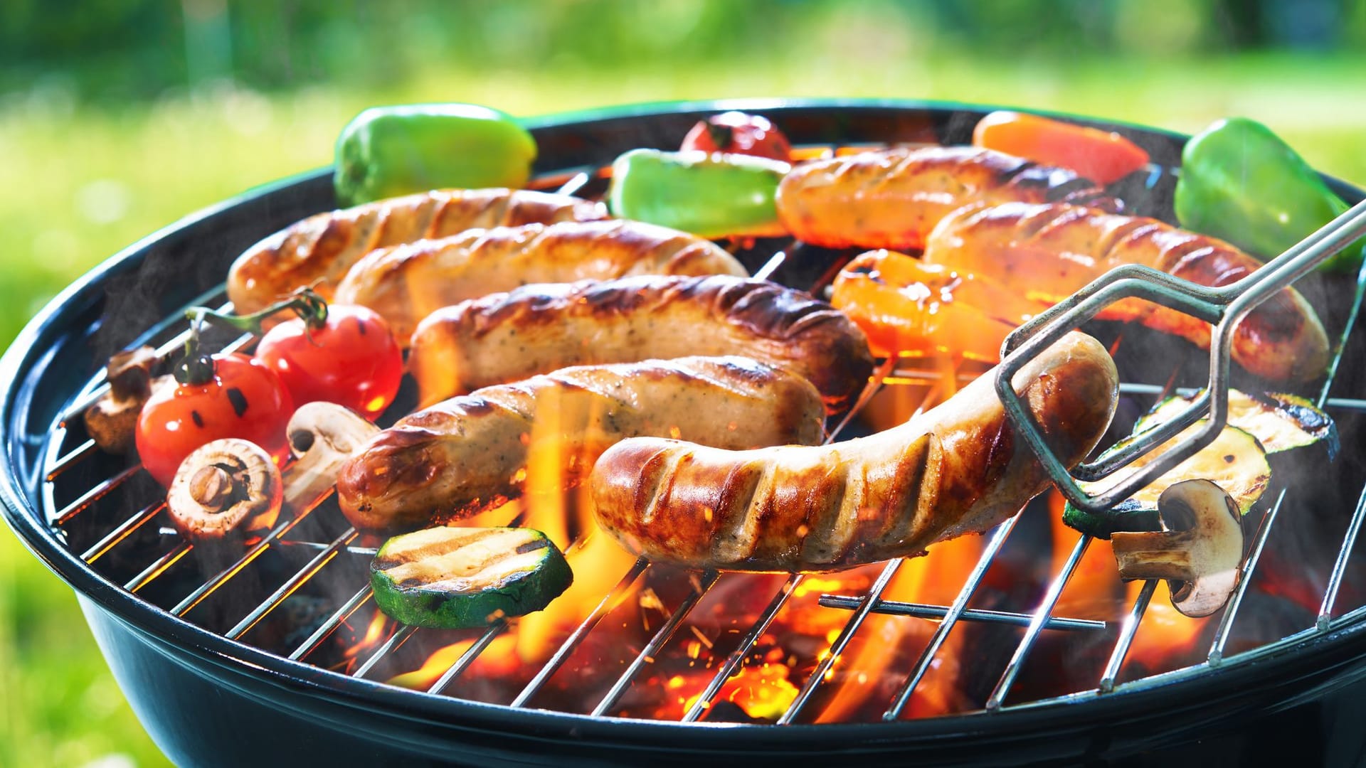 Fleisch und Würstchen werden gegrillt Fleisch und Würstchen werden gegrillt