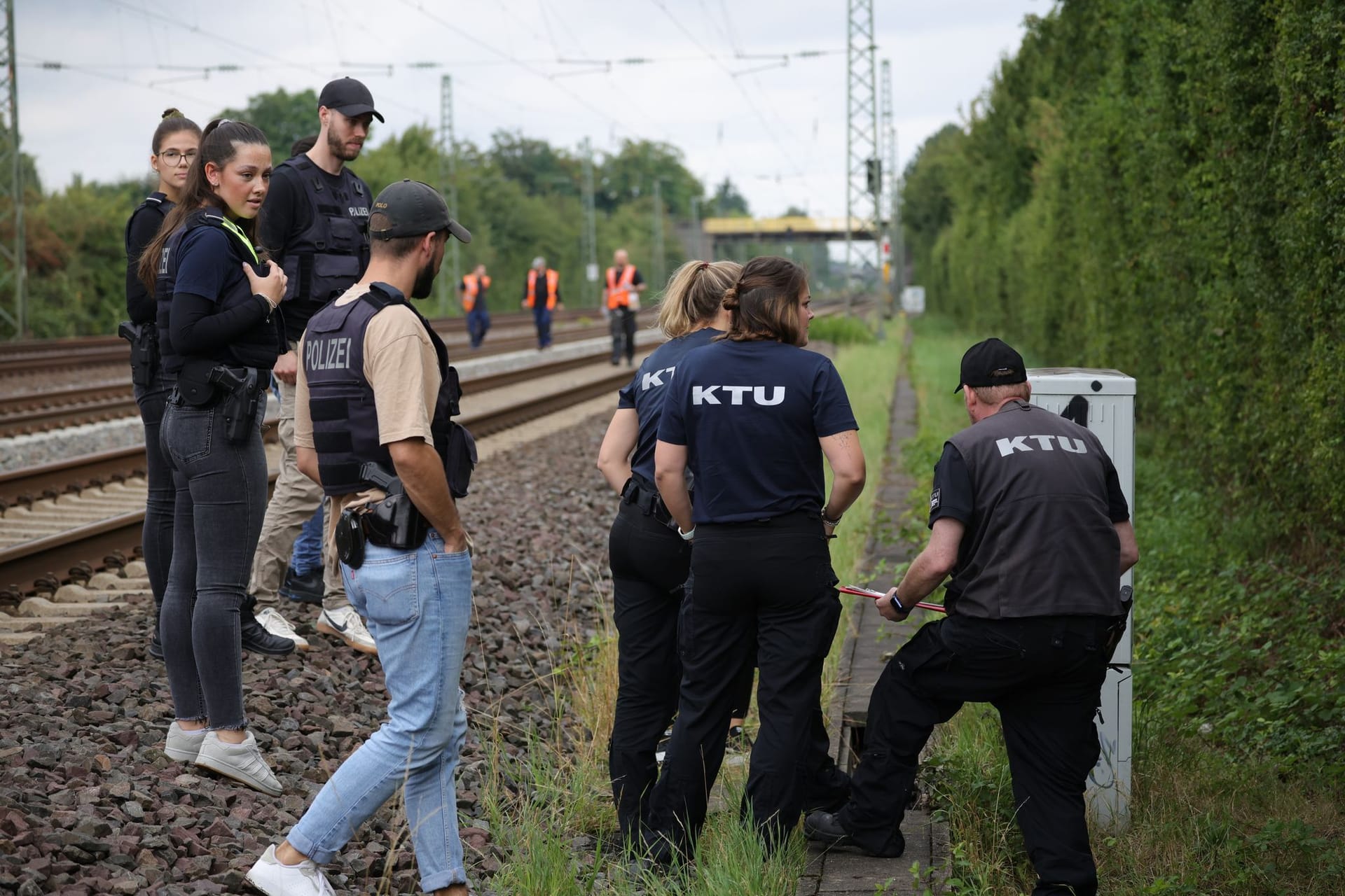 Mitarbeiter der Spurensicherung und der KTU (Kriminaltechnische Untersuchung) stehen in der Nähe der Bahngleise. Auf der Strecke der Deutschen Bahn ist ein weiterer Brandsatz entdeckt worden.