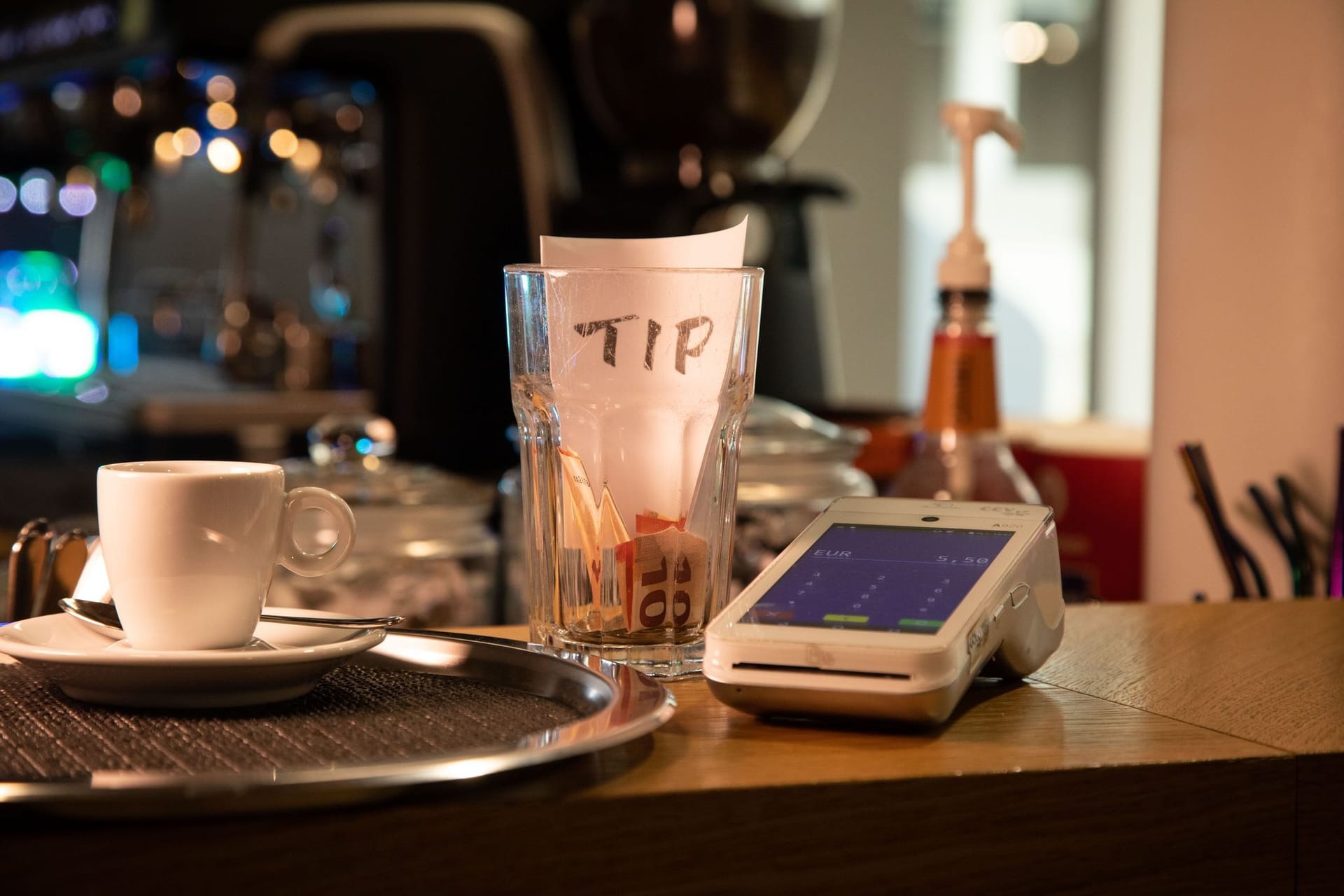 Tresen mit Trinkgeldbecher und Kartenlesegerät an einer Kaffeebar