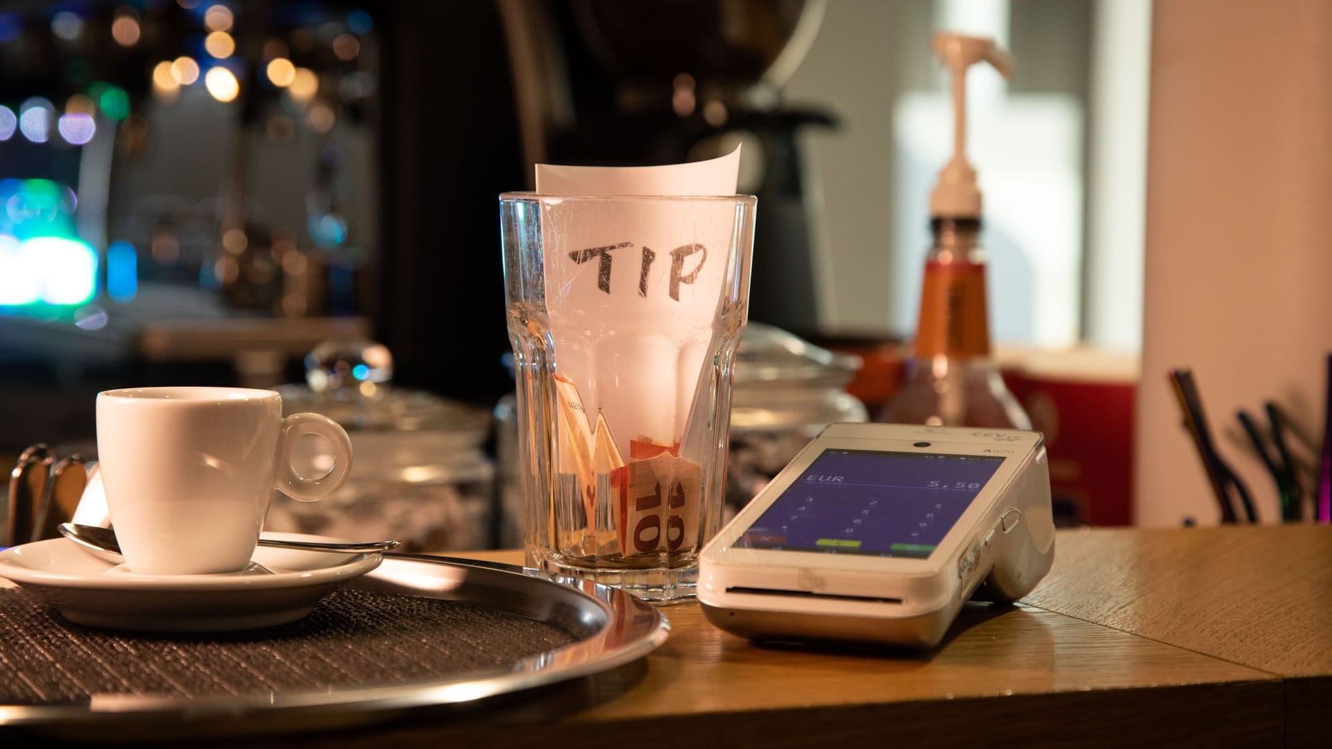 Tresen mit Trinkgeldbecher und Kartenlesegerät an einer Kaffeebar