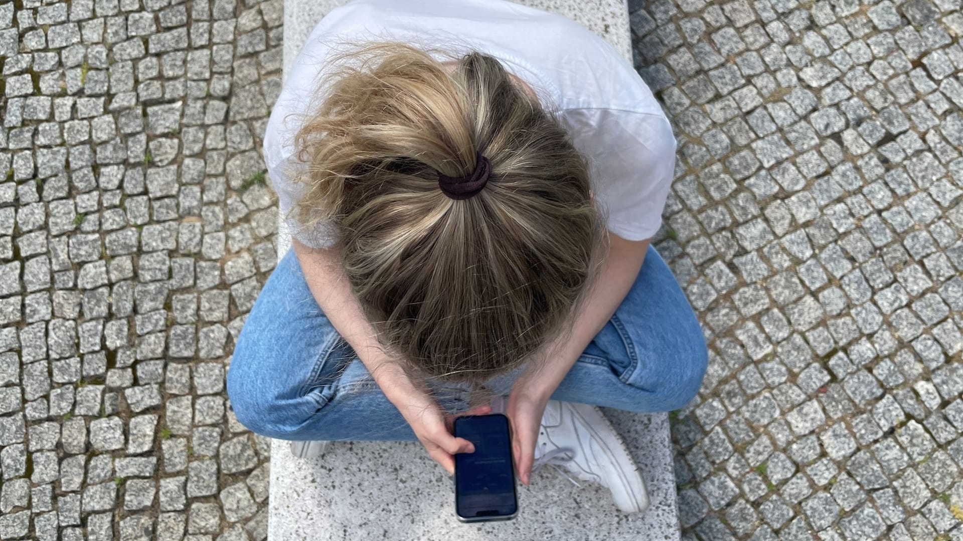 Eine Frau schaut auf ihr Smartphone