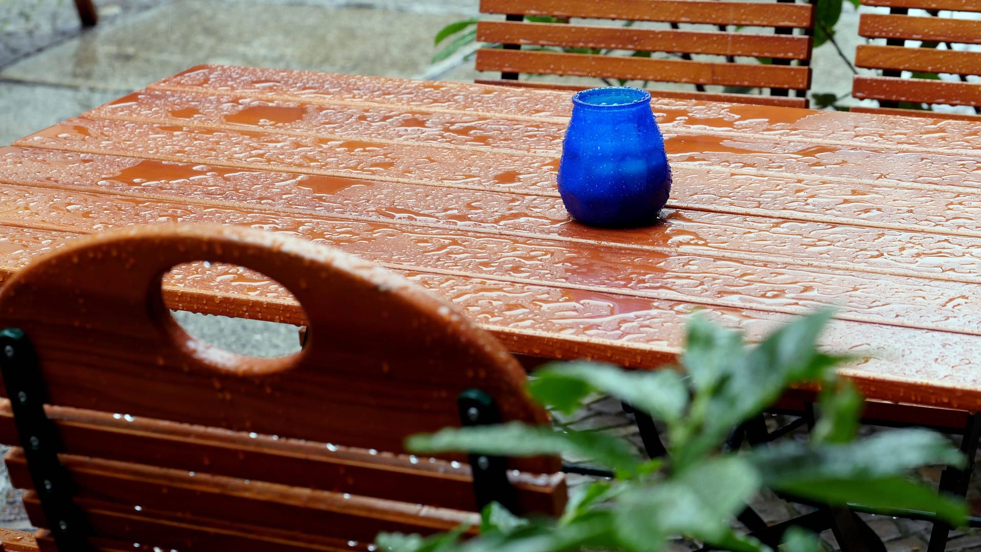 Tische und Stühle (Archivbild): Das Regenwetter verdirbt der Gastronomie die Außensaison.