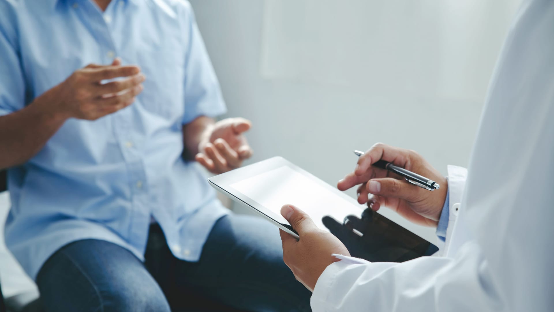 Ein Arzt spricht mit einem Patienten über einen Laborbefund.