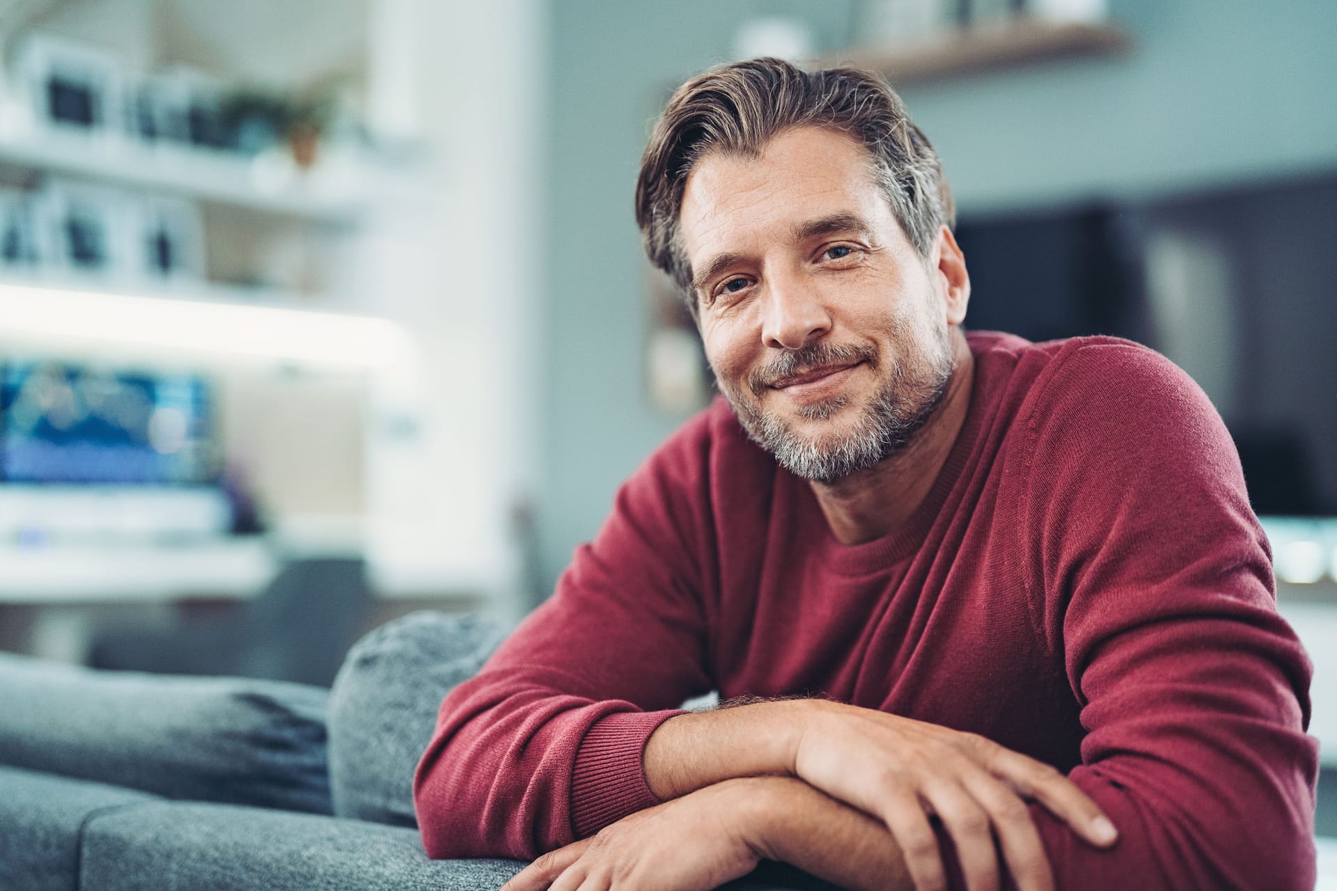 Mann mittleren Alters auf dem Sofa: Viele Untersuchungen zur Früherkennung werden von den Krankenkassen bezahlt.
