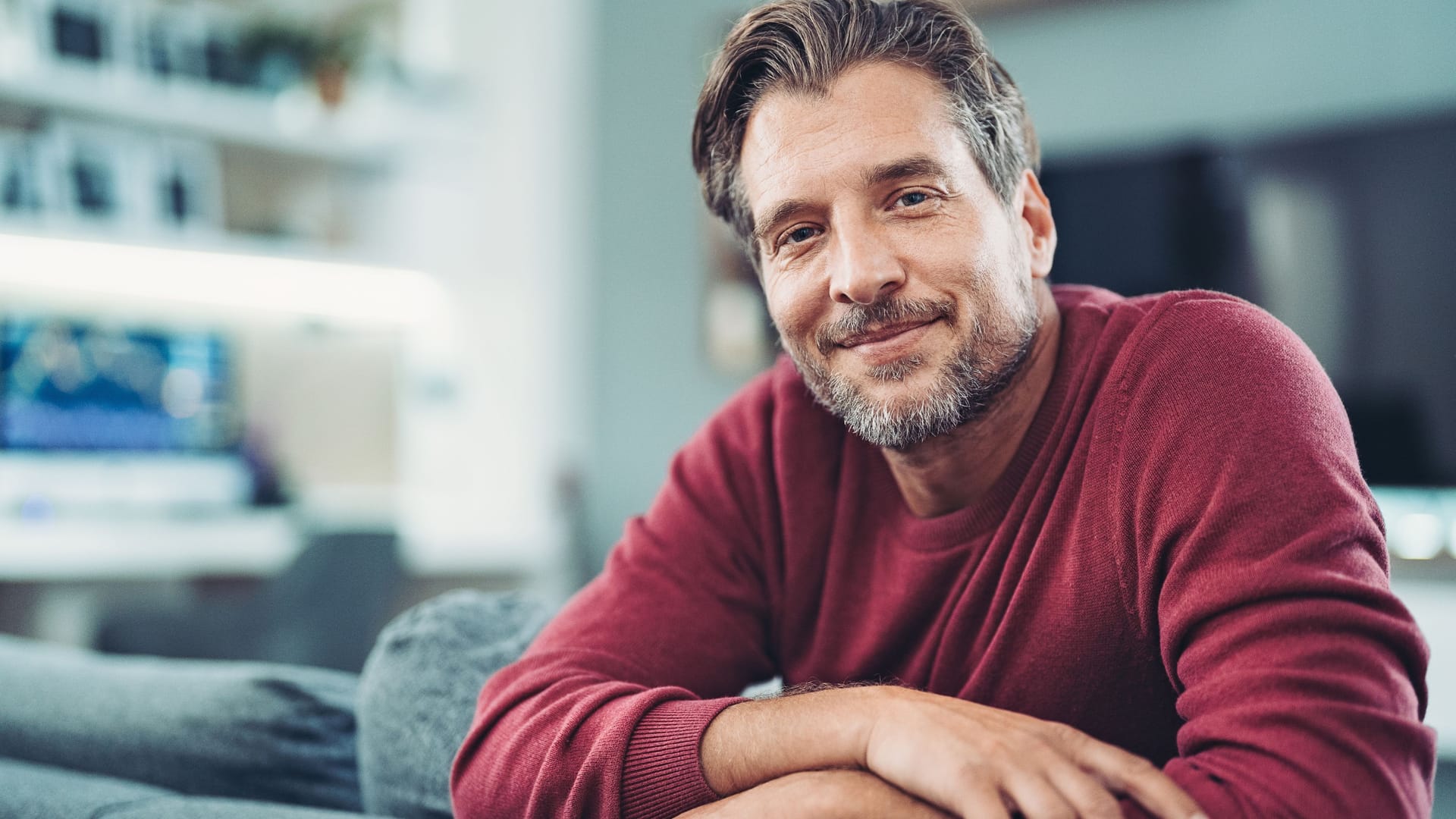 Mann mittleren Alters auf dem Sofa: Viele Untersuchungen zur Früherkennung werden von den Krankenkassen bezahlt.