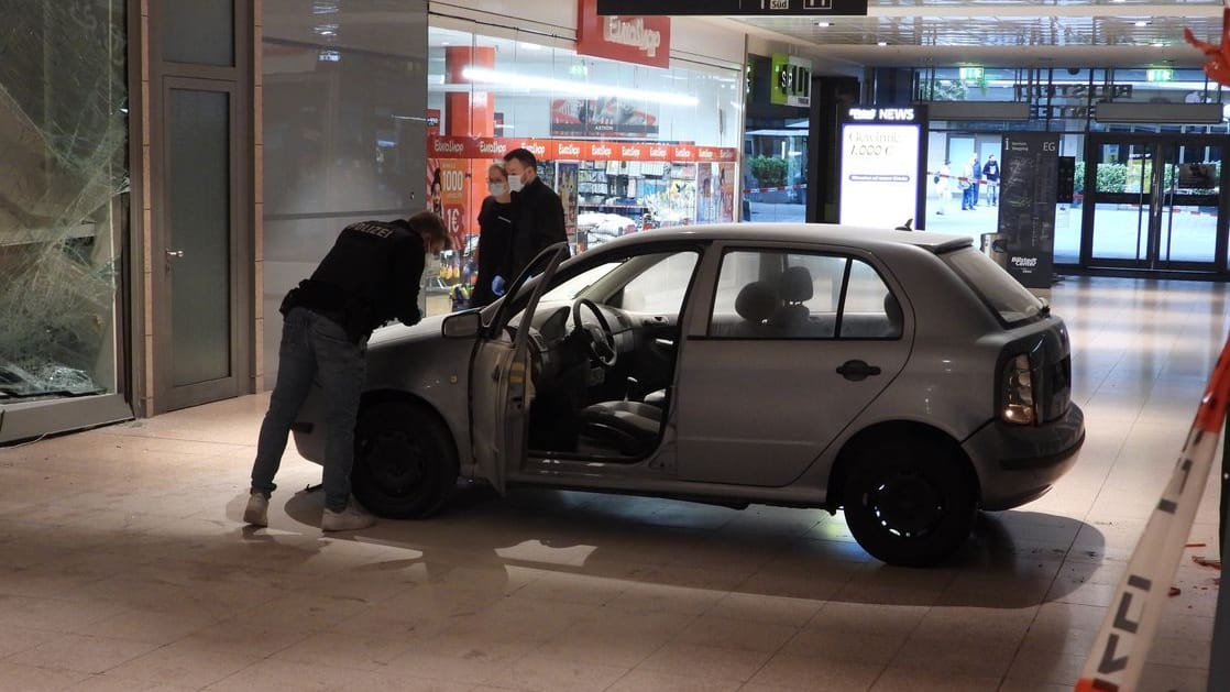 Polizeibeamte stehen an einem Auto im Einkaufszentrum in Hamburg-Billstedt : Ein Auto ist durch die Schaufensterscheibe eines Juweliergeschäfts gefahren. Polizeibeamte stehen an einem Auto im Einkaufszentrum in Hamburg-Billstedt : Ein Auto ist durch die Schaufensterscheibe eines Juweliergeschäfts gefahren.