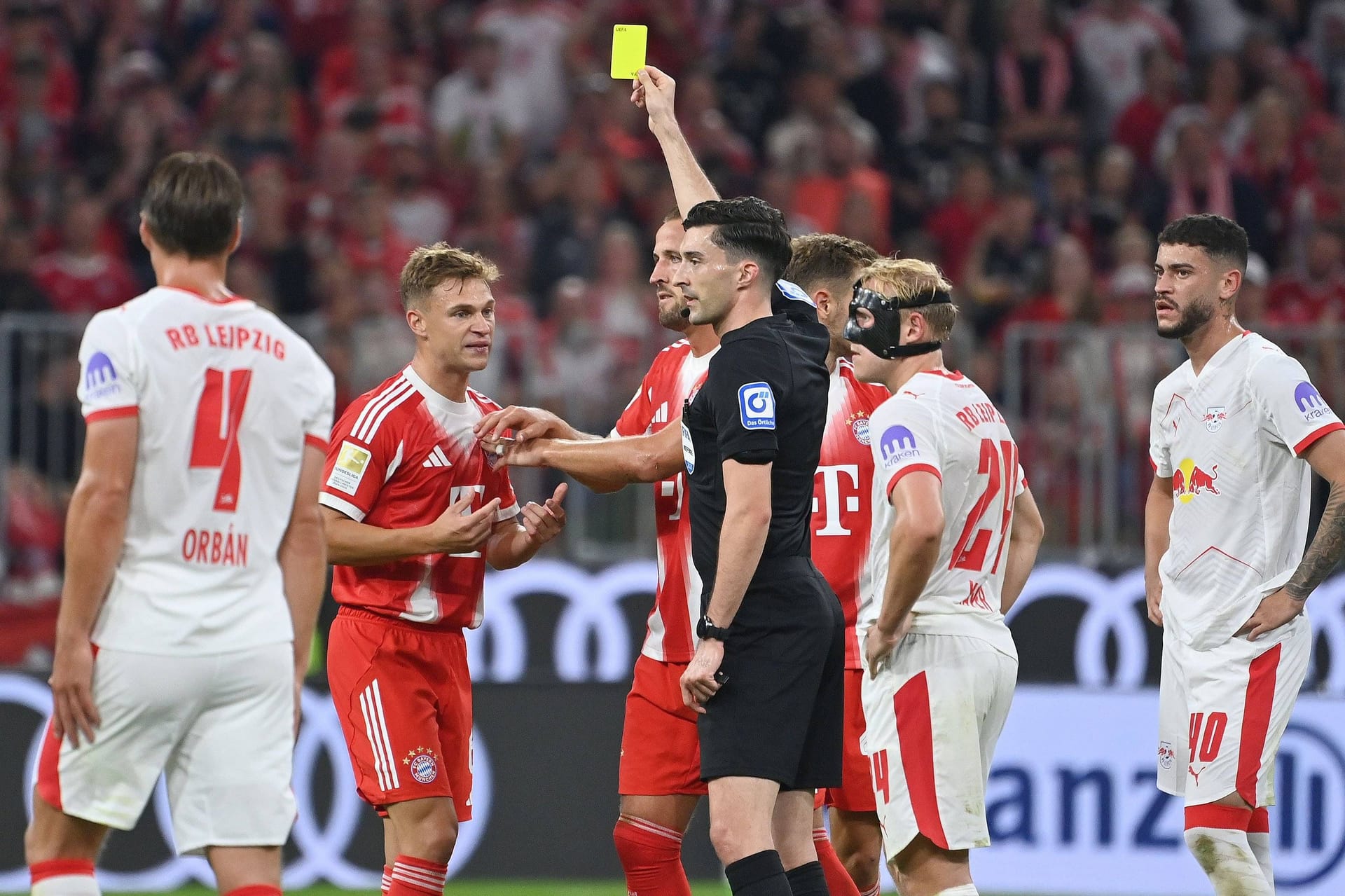 Schiedsrichter Florian Badstübner (in Schwarz) zeigt Joshua Kimmich (l.) die Gelbe Karte. Schiedsrichter Florian Badstübner (in Schwarz) zeigt Joshua Kimmich (l.) die Gelbe Karte.