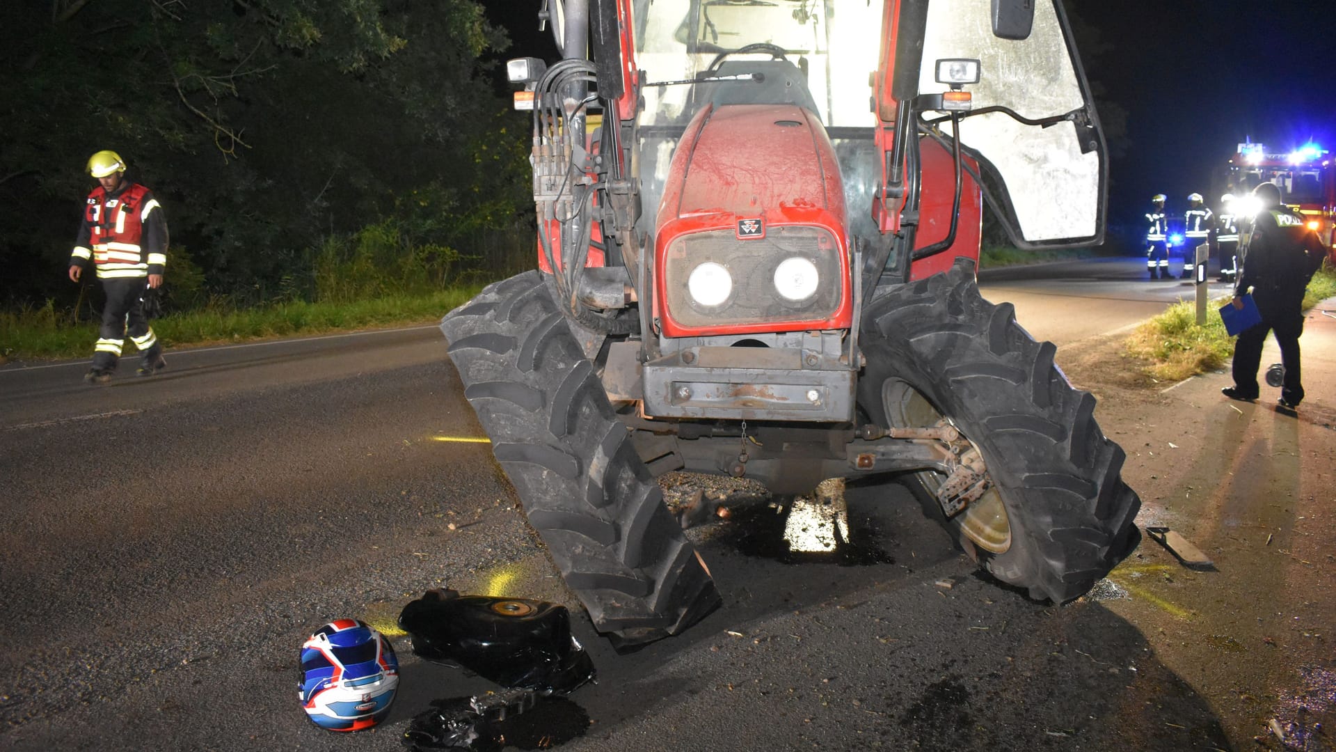 Der schwer beschädigte Traktor steht auf der L111: Vor dem Fahrzeug liegt der Helm des schwer verletzten Motorradfahrers.