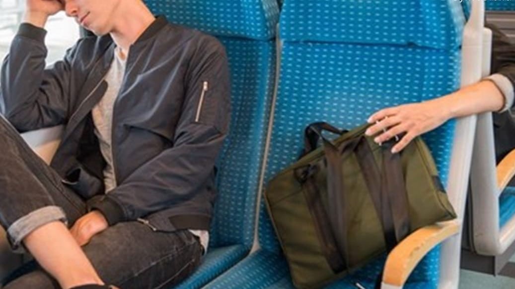 Ein Zugreisender schläft, währen seine Tasche entwendet wird (Symbolbild): Einen kurzen Moment der Unachtsamkeit nutzte ein Dieb im Nachtzug nach München aus.
