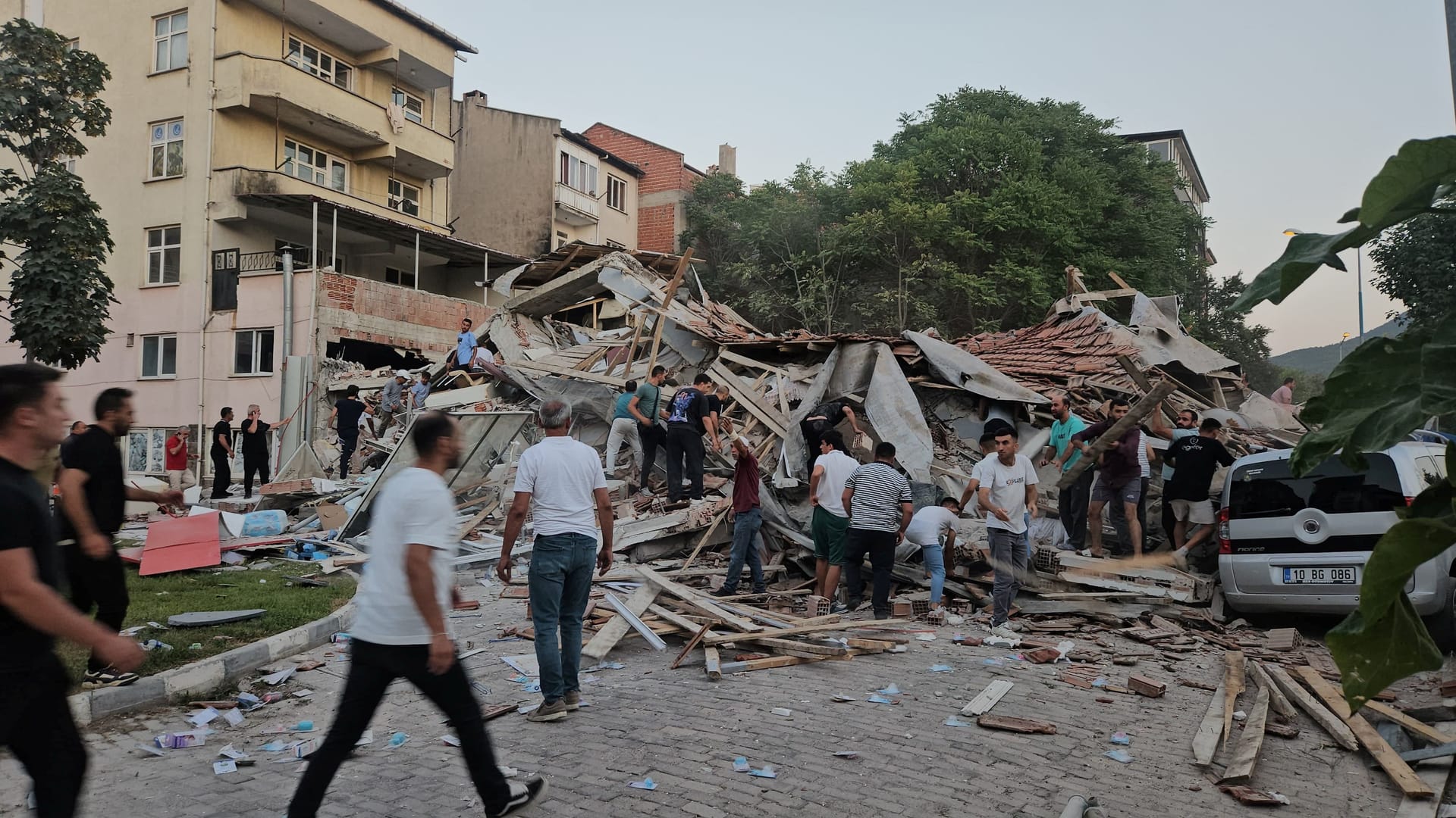 Menschen eilen herbei, um Verschüttete aus einem eingestürzten Haus in Sindirgi, im Westen der Türkei, zu retten.