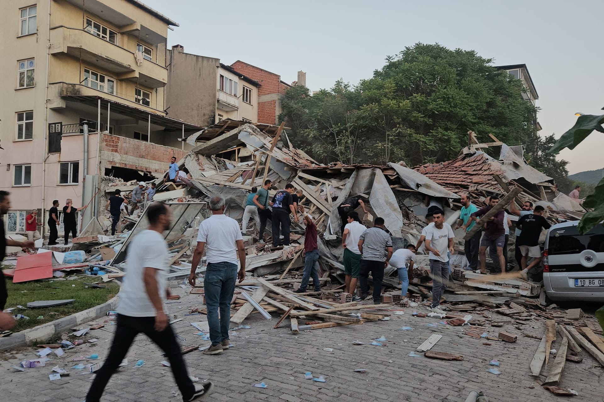 Menschen eilen herbei, um Verschüttete aus einem eingestürzten Haus in Sindirgi, im Westen der Türkei, zu retten. Menschen eilen herbei, um Verschüttete aus einem eingestürzten Haus in Sindirgi, im Westen der Türkei, zu retten.