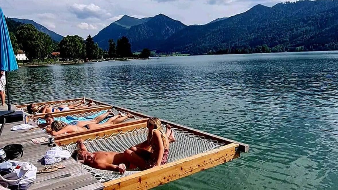 Auf netzartigen Liegen im Wasser des Schliersees fühlt sich der Sommer in München wie Urlaub an. Auf netzartigen Liegen im Wasser des Schliersees fühlt sich der Sommer in München wie Urlaub an.