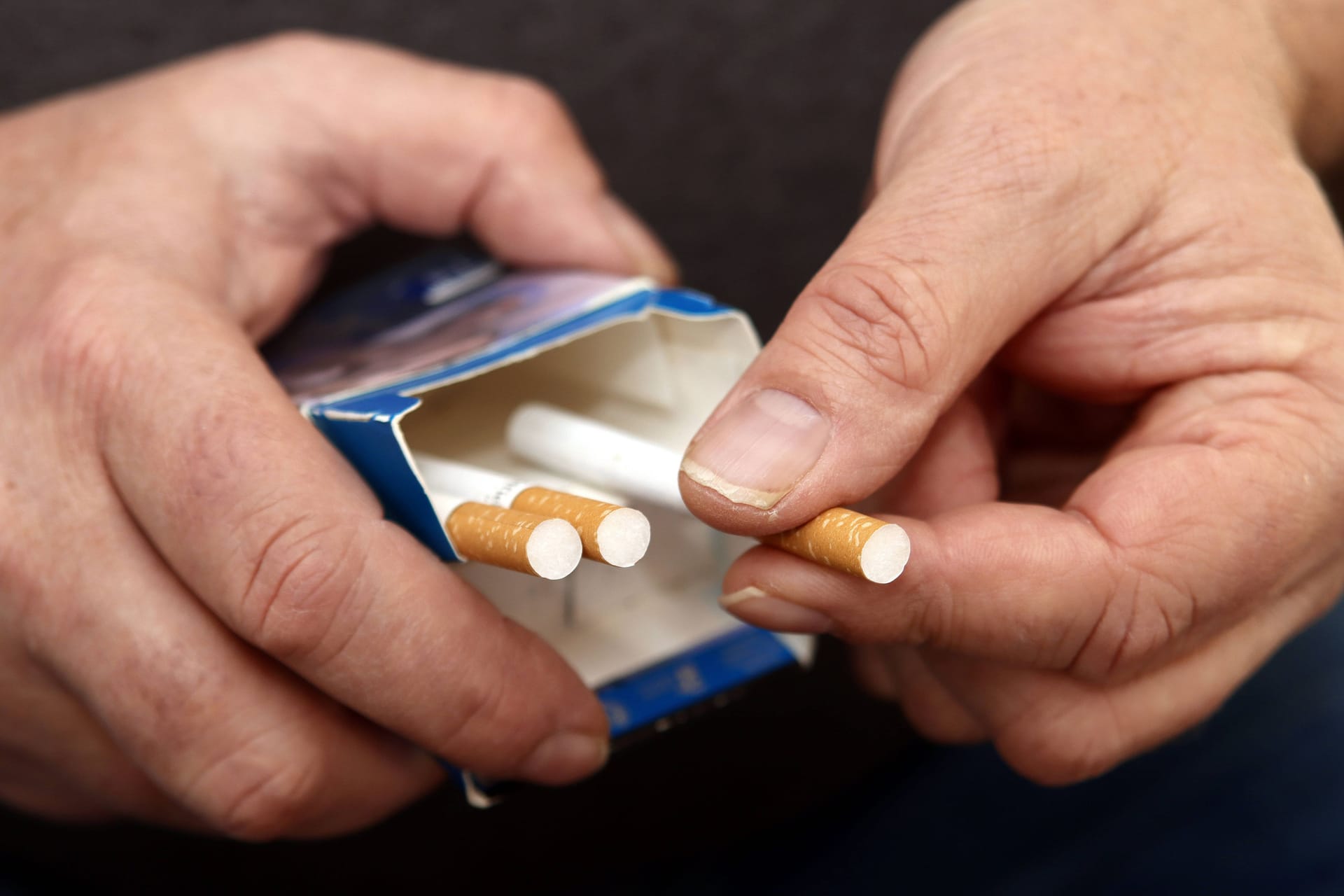 Mann hält Zigarettenschachtel in der Hand