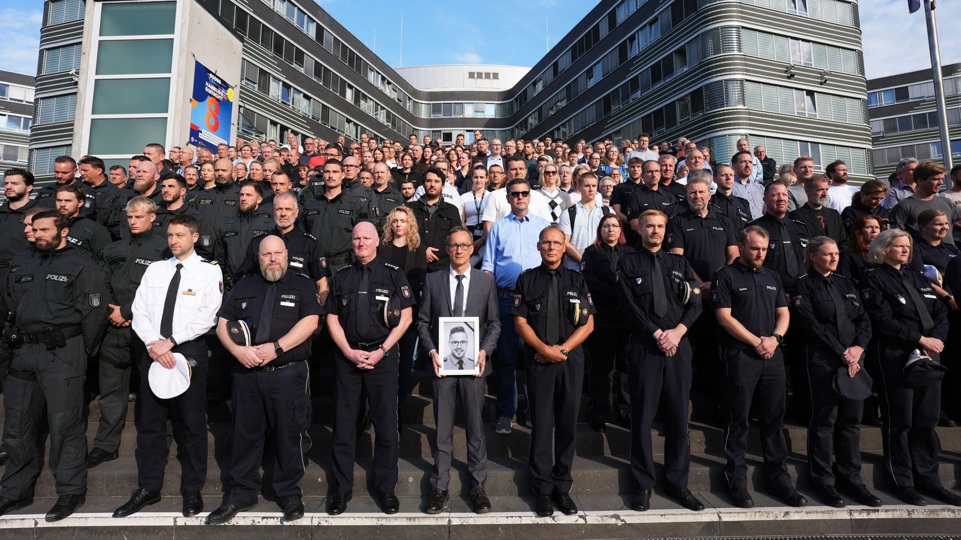 Falk Schnabel (vorne Mitte), Polizeipräsident von Hamburg, hält ein Foto des getöteten Kollegen in der Hand: Die Polizei hielt am Mittwoch eine Schweigeminute ab.
