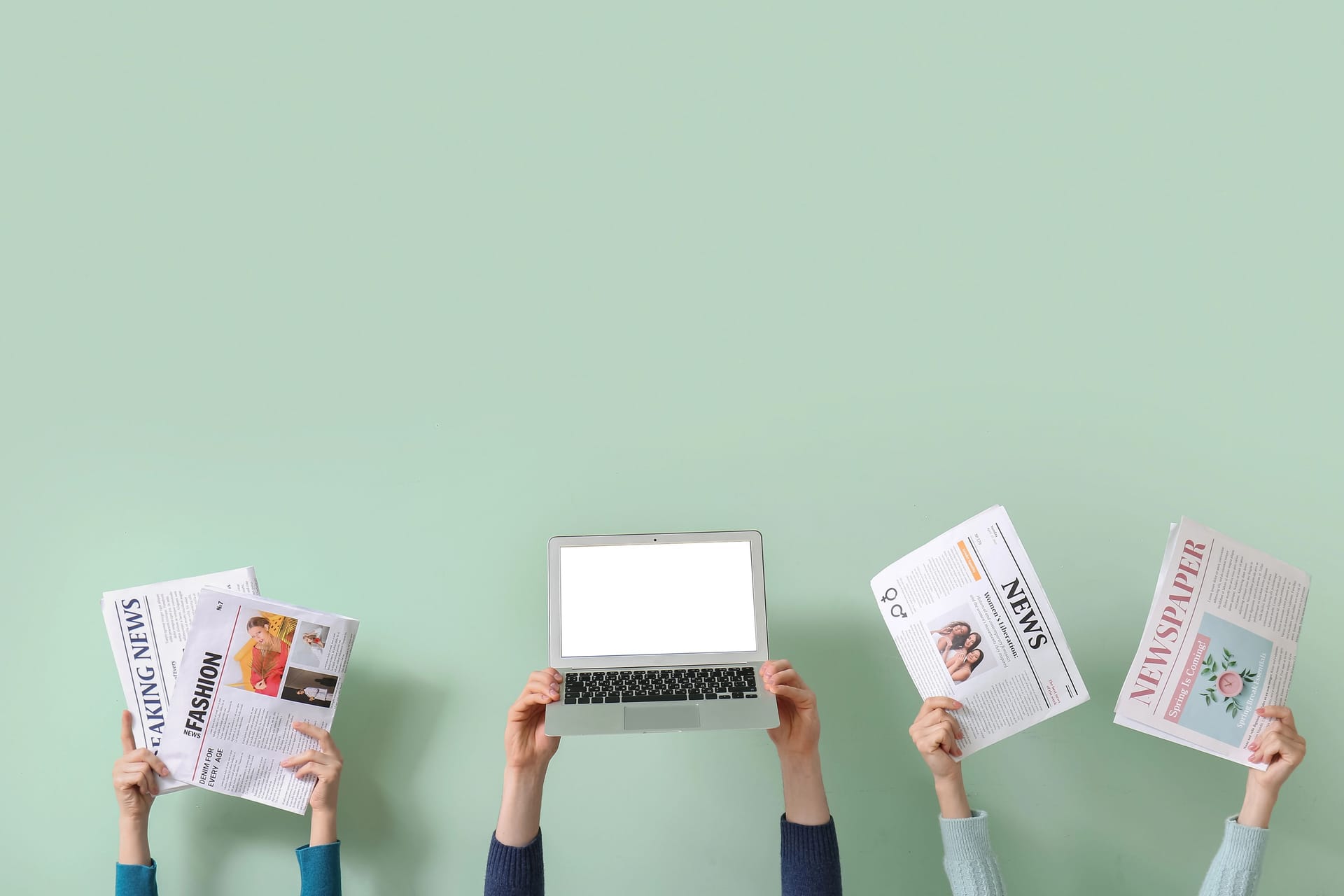 Hände halten Zeitungen und einen Laptop in die Höhe: Ob analog oder digital – wie gut kennen Sie sich mit den Medien in Deutschland und den USA aus?