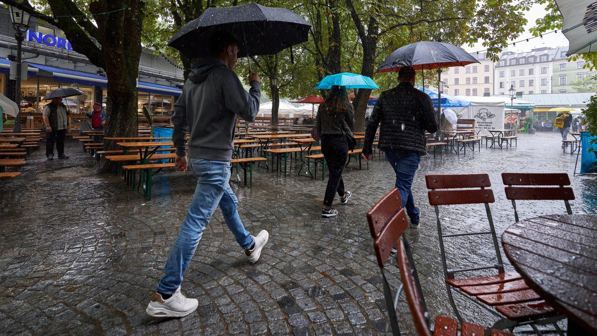 Der Biergarten am Viktualienmarkt im Starkregen (Archivbild): Das Wetter in München ist geprägt von Regenschauern und kühlen Temperaturen.