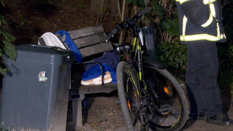 Die Sachen des Jungen liegen auf einer Bank, davor steht sein Fahrrad.