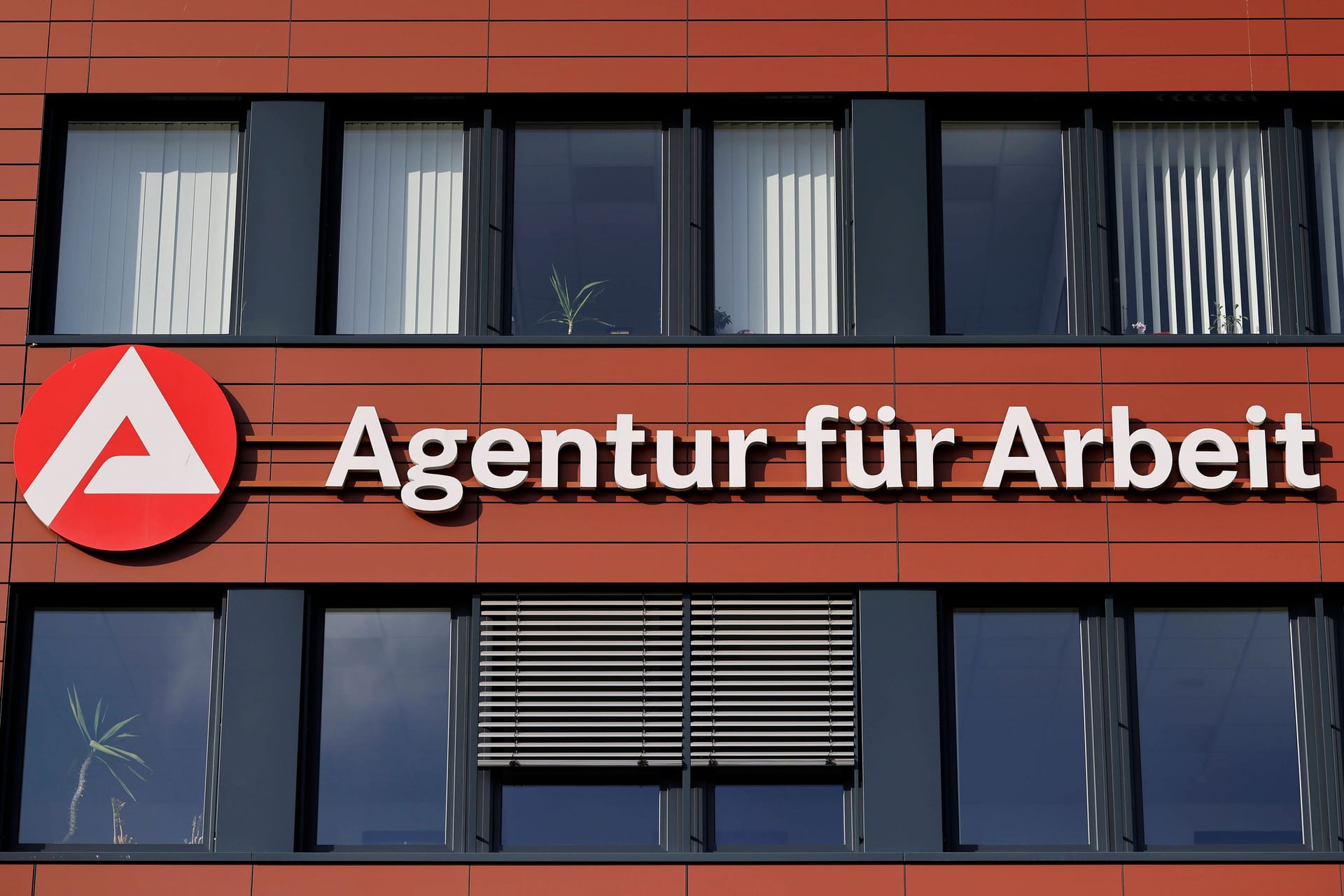 Logo der Agentur für Arbeit an einer Hauswand (Symbolbild): Selbst in Regionen mit hohen Mieten lohnt es sich, arbeiten zu gehen.
