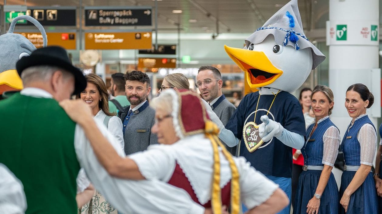 Tracht trifft Terminal: Lufthansa-Crew, Trachtengruppen und Maskottchen "Lu" feiern am Münchner Flughafen den Auftakt zur Wiesn – inklusive bayerischem Tanz und Blasmusik. Tracht trifft Terminal: Lufthansa-Crew, Trachtengruppen und Maskottchen "Lu" feiern am Münchner Flughafen den Auftakt zur Wiesn – inklusive bayerischem Tanz und Blasmusik.