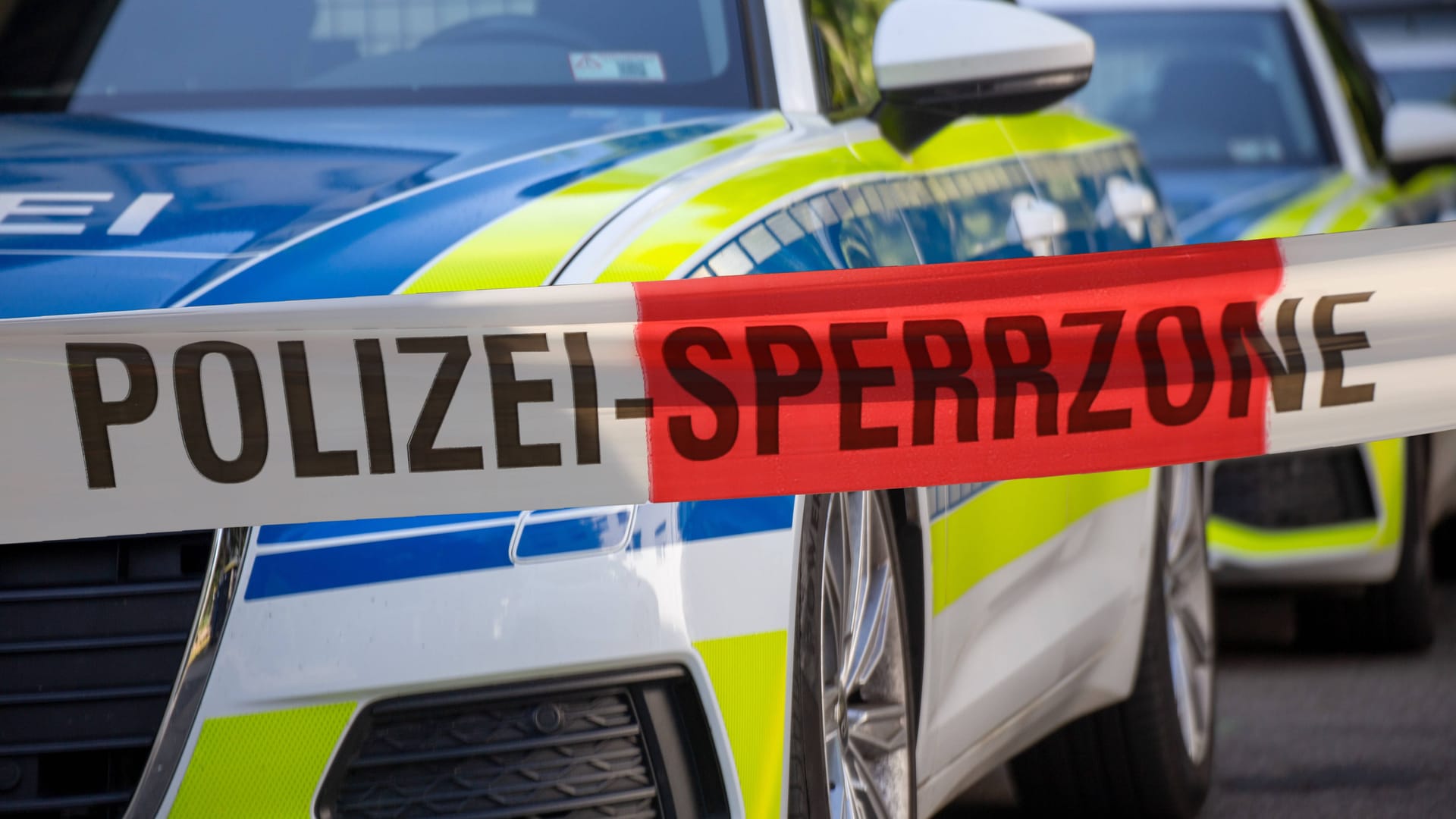 Polizeiautos hinter einem Absperrband (Symbolbild): Polizeiautos hinter einem Absperrband (Symbolbild):
