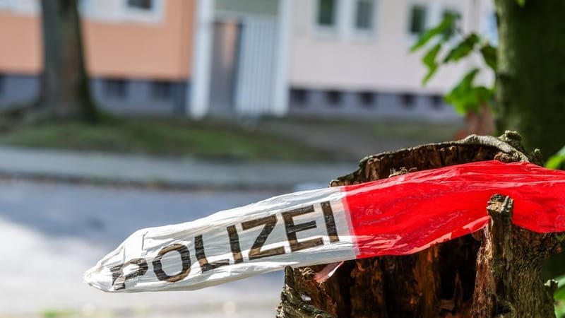 Unweit des Tatorts hängen Reste vom polizeilichen Absperrband: Im Hintergrund steht das Haus, vor dem die Tat stattgefunden hat. Unweit des Tatorts hängen Reste vom polizeilichen Absperrband: Im Hintergrund steht das Haus, vor dem die Tat stattgefunden hat.