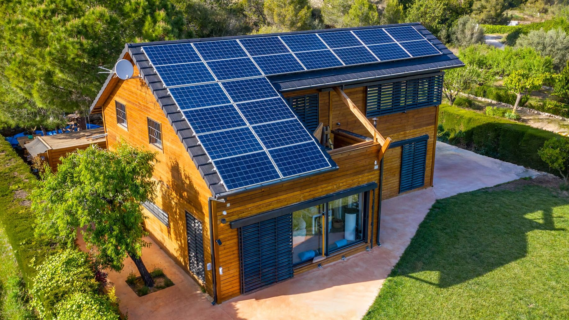 Haus mit Holzfassade und Solaranlage auf dem Dach Haus mit Holzfassade und Solaranlage auf dem Dach
