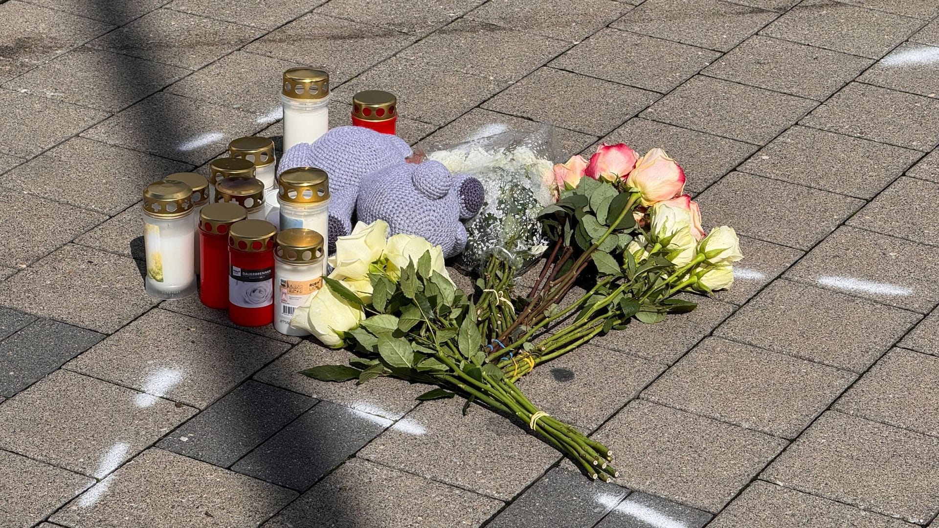 Markierungen mit Sprühfarben und Trauerbekundungen sind auf einem Parkplatz zu sehen. Nach einem Streit soll ein 18-Jähriger einen 12 Jahre alten Jungen in Niedernhall totgefahren haben.