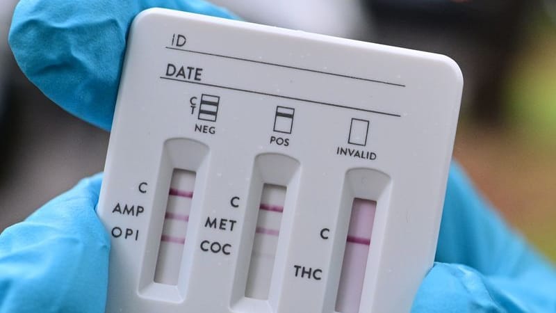 Ein Polizeibeamter hält während einer Polizeikontrolle auf Drogen im Straßenverkehr auf dem Tempelhofer Damm einen Drogentest für Urin in der Hand, der ein positives Ergebnis für THC anzeigt.