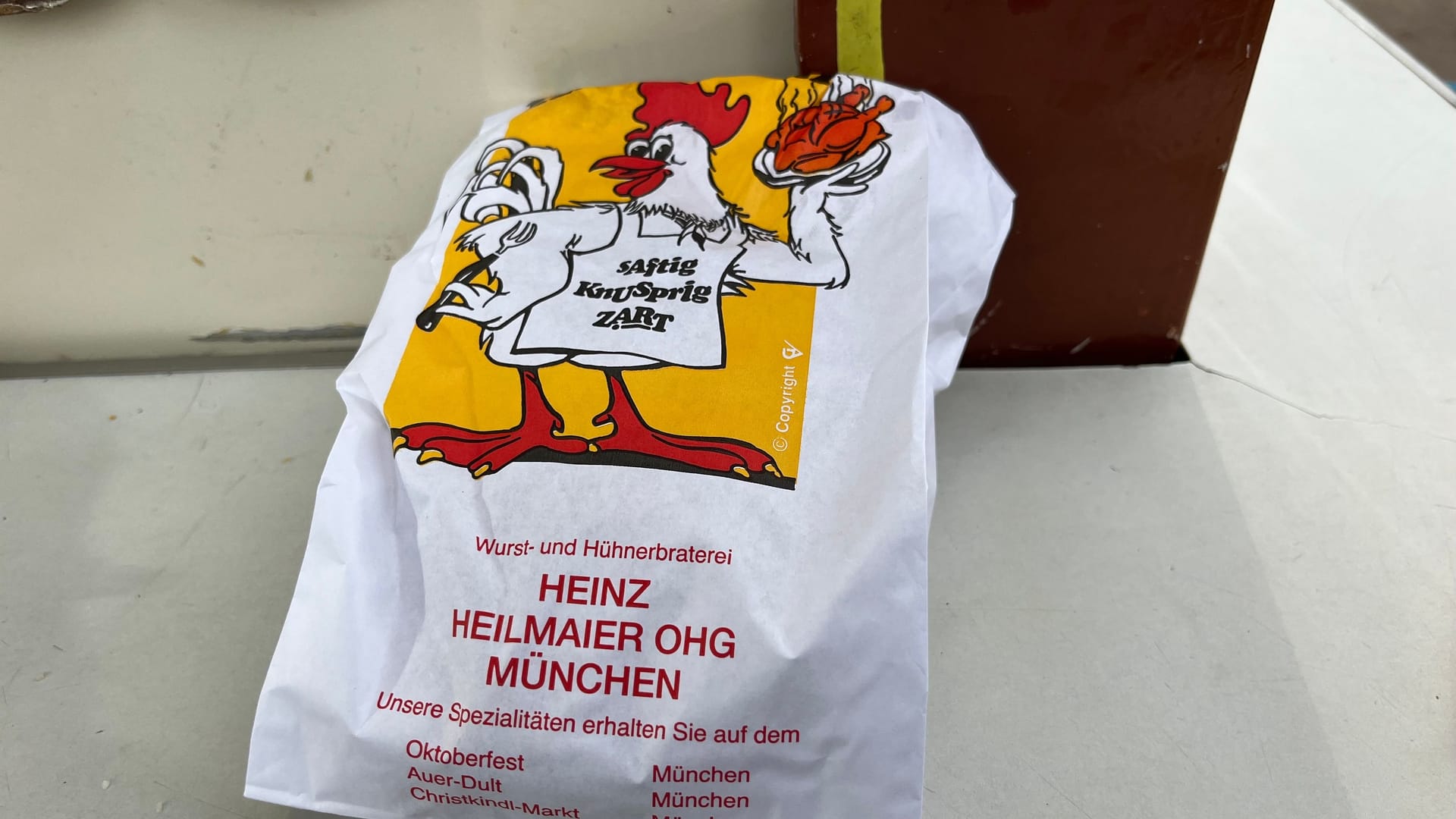 Wer das Hühnchen am Stand bestellt, bekommt es in einer Tüte: Im dazugehörigen Zelt kostet der Klassiker einen Euro mehr als an der Theke. Wer das Hühnchen am Stand bestellt, bekommt es in einer Tüte: Im dazugehörigen Zelt kostet der Klassiker einen Euro mehr als an der Theke.