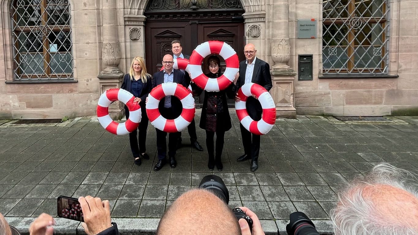 Mittelfrankens Städtekämmerer mit Rettungsringen vor dem Nürnberger Rathaus: Sie fordern mehr Geld vom Bund.