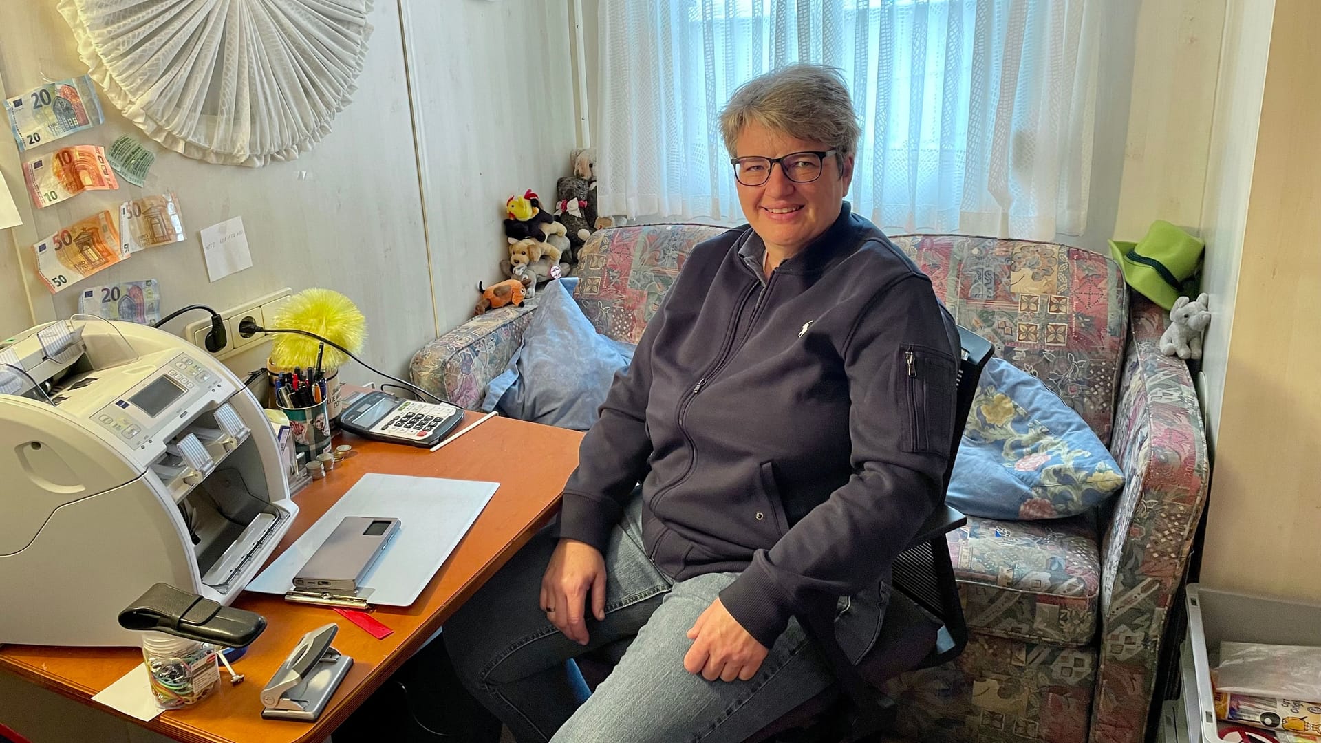 Schaustellerin Angela Bruch in ihrem Mini-Büro der Alpina-Bahn: Links an der Wand hängt Falschgeld, das ihr Fahrgäste untergejubelt haben. Schaustellerin Angela Bruch in ihrem Mini-Büro der Alpina-Bahn: Links an der Wand hängt Falschgeld, das ihr Fahrgäste untergejubelt haben.