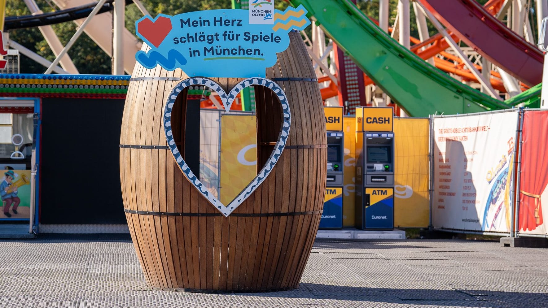 "Mein Herz schlägt für Spiele in München" steht auf der Fotobox, die die Stadt München vor dem Olympia Looping platziert hat.