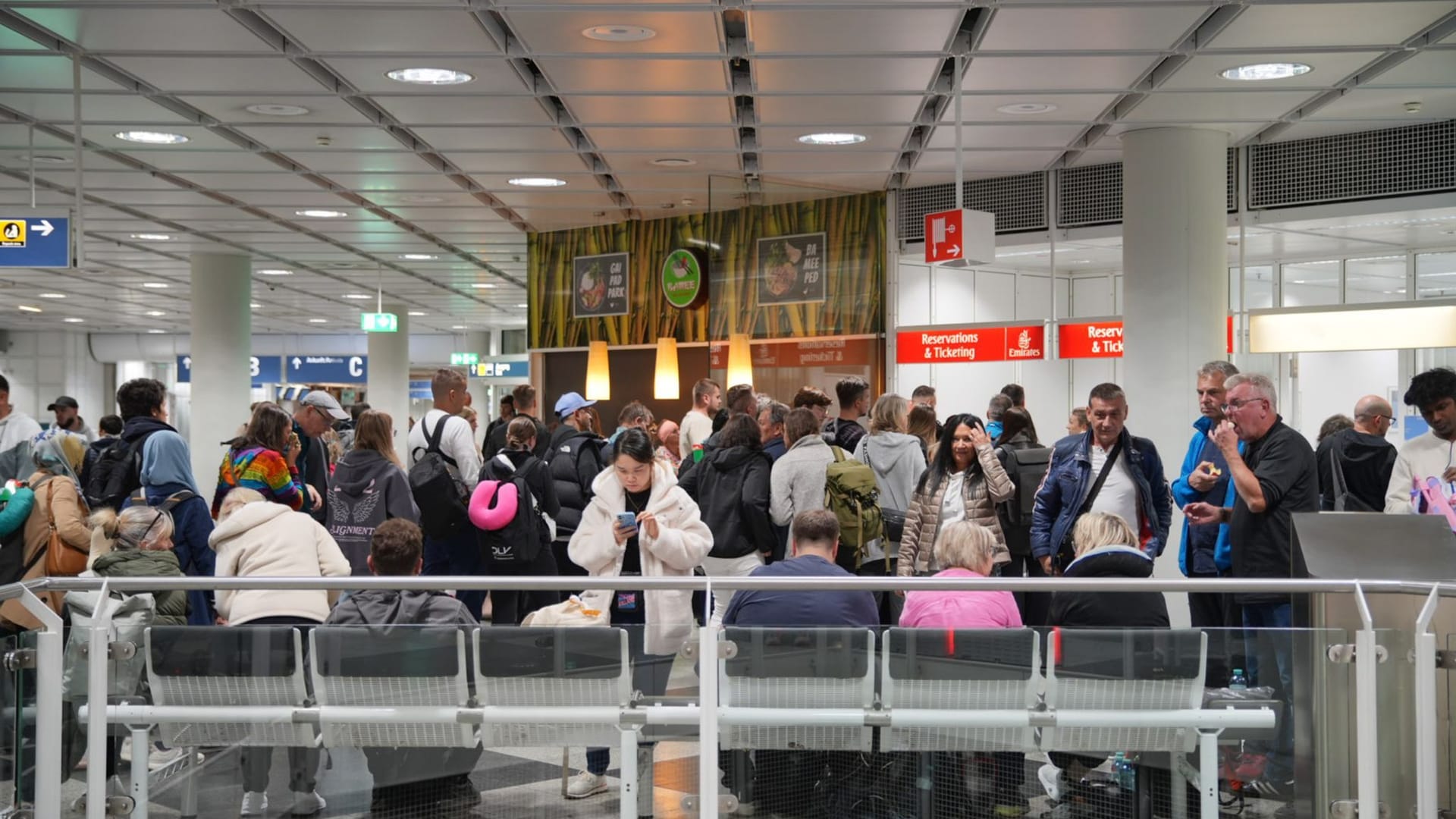 Menschen warten am Flughafen München, nachdem der Betrieb wegen möglicher Drohnensichtungen eingestellt wurde.