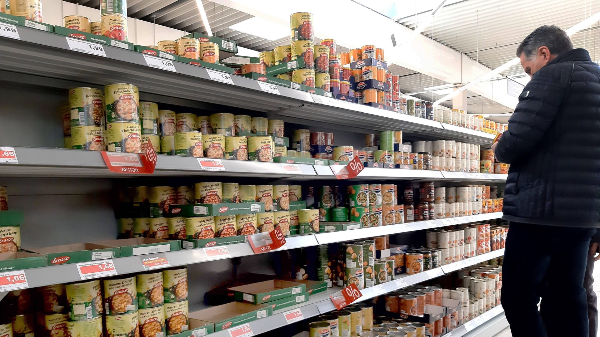 Mann steht vor einem Supermarktregal mit Konservendosen (Symbolfoto): Ein Hersteller aus Hamburg warnt vor dem Verzehr seiner braunen Linsen. Mann steht vor einem Supermarktregal mit Konservendosen (Symbolfoto): Ein Hersteller aus Hamburg warnt vor dem Verzehr seiner braunen Linsen.