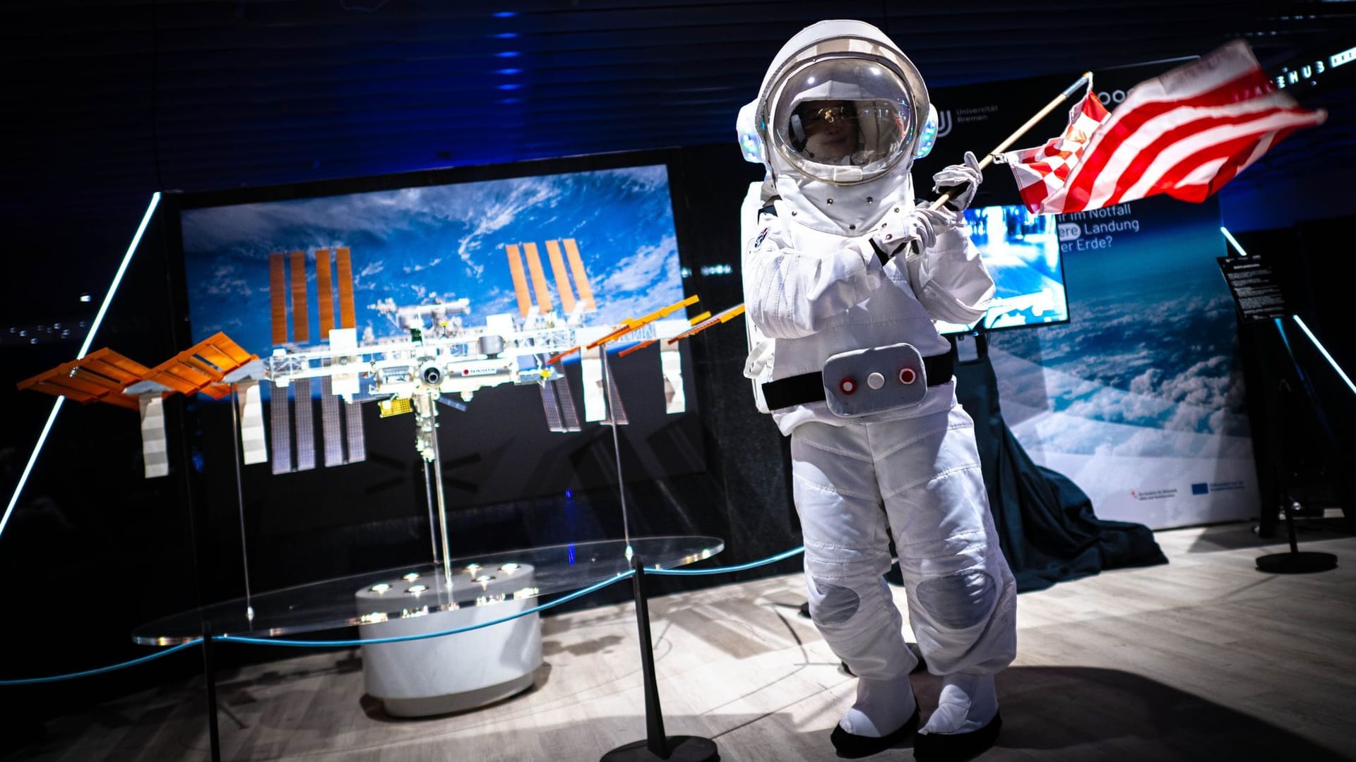 Eine Astronautin schwingt in der Ausstellung "Space Hub" eine Bremen-Flagge. Die Ausstellung ist bis Ende November im ehemaligen Kaufhof-Gebäude zu sehen.
