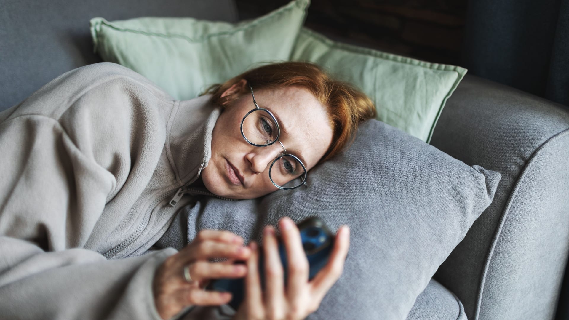 Eine Frau schaut sorgenvoll aufs Handy: