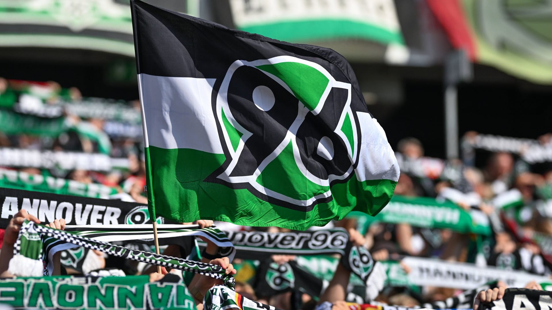 96-Fans halten Schals und eine Fahne in die Luft (Archivbild): Ende Oktober steht das Niedersachsenderby in Braunschweig an. 96-Fans halten Schals und eine Fahne in die Luft (Archivbild): Ende Oktober steht das Niedersachsenderby in Braunschweig an.