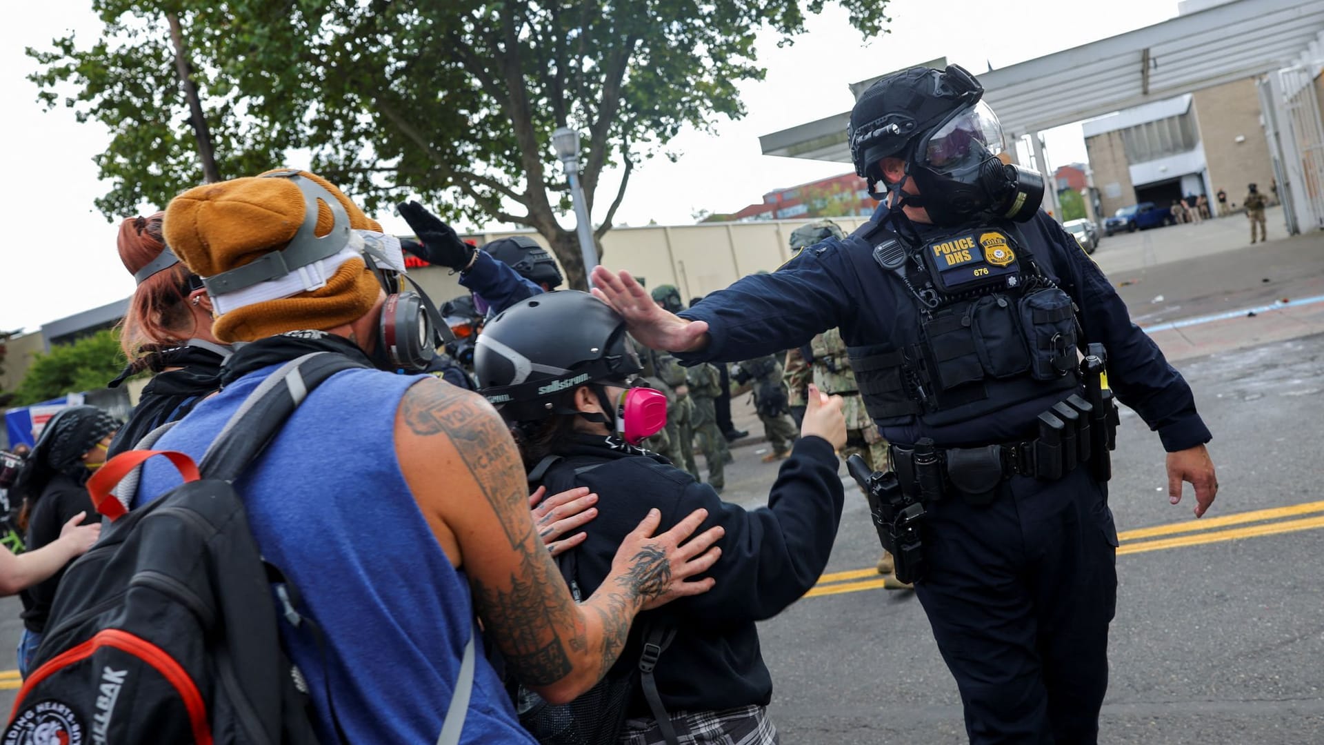 Ein Polizist greift an den Helm eines Demonstranten in der Stadt Portland. Ein Polizist greift an den Helm eines Demonstranten in der Stadt Portland.