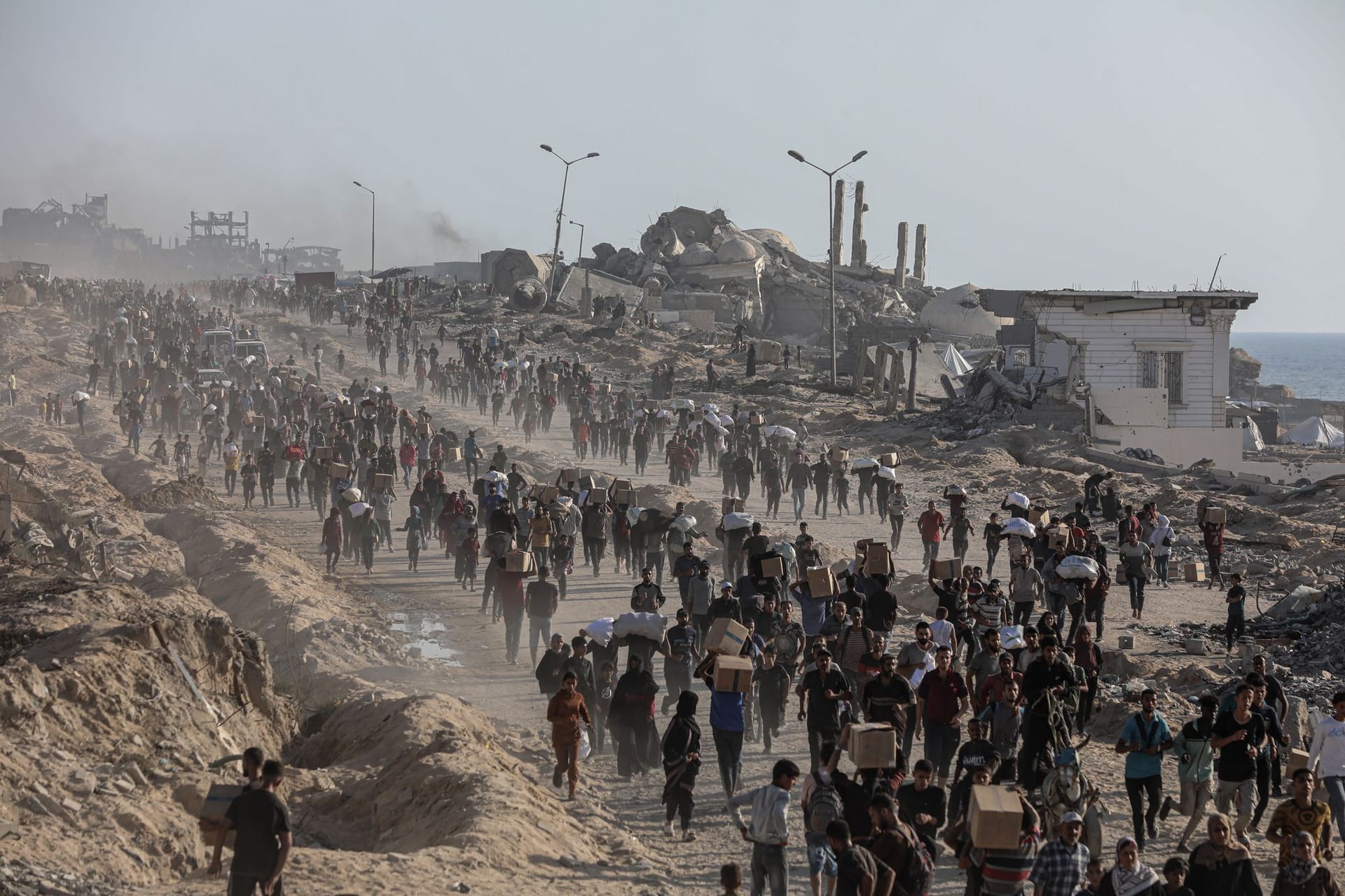 Palästinenser kehren mit Hilfspaketen in die Stadt Gaza zurück. Palästinenser kehren mit Hilfspaketen in die Stadt Gaza zurück.