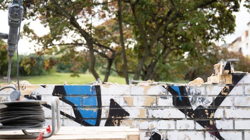 Ein Abbruchwerkzeug steckt in einer Mauer am Görlitzer Park. Ein Abbruchwerkzeug steckt in einer Mauer am Görlitzer Park.