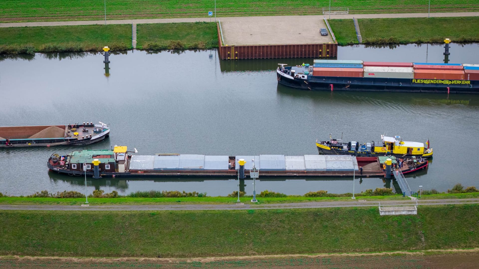 Ein Binnenschiff (vorne) mit Leck liegt vor der Schleuse Dörverden. Taucher sollen nun die undichte Stelle finden und verschließen. Ein Binnenschiff (vorne) mit Leck liegt vor der Schleuse Dörverden. Taucher sollen nun die undichte Stelle finden und verschließen.